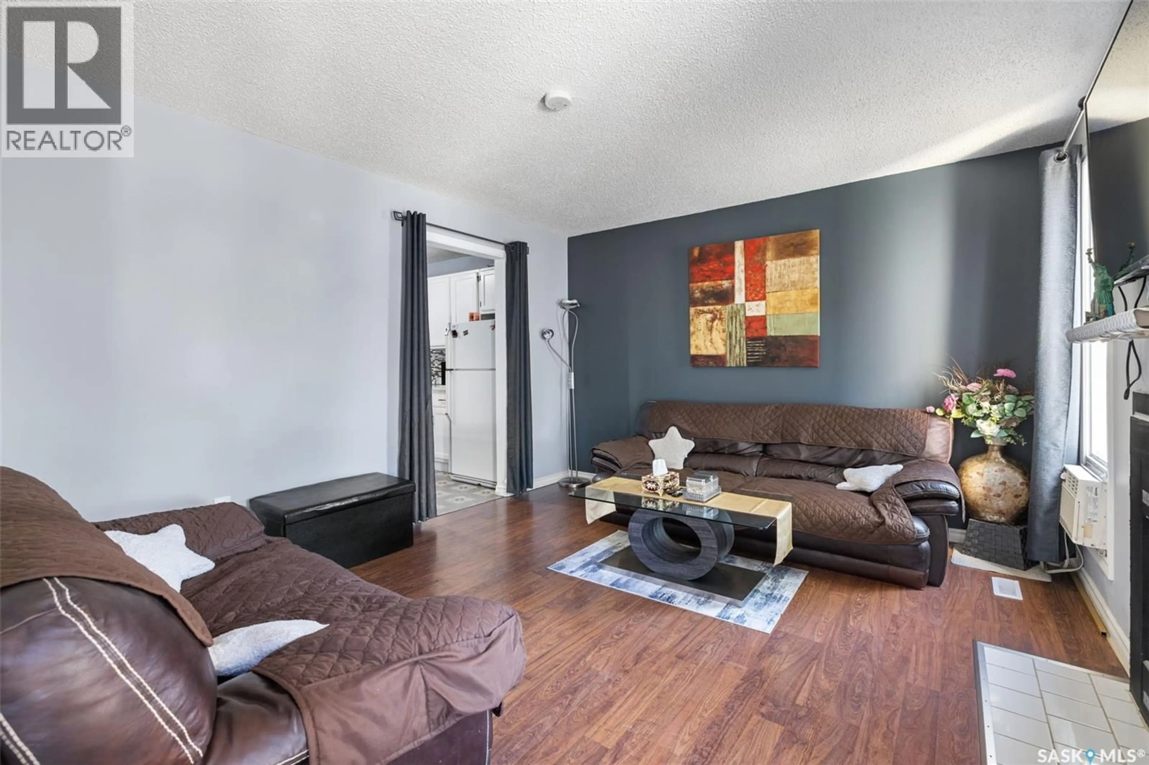 Living room with furniture, wood/laminate floor for 139 THOMSON AVENUE, Regina Saskatchewan S4N5L2