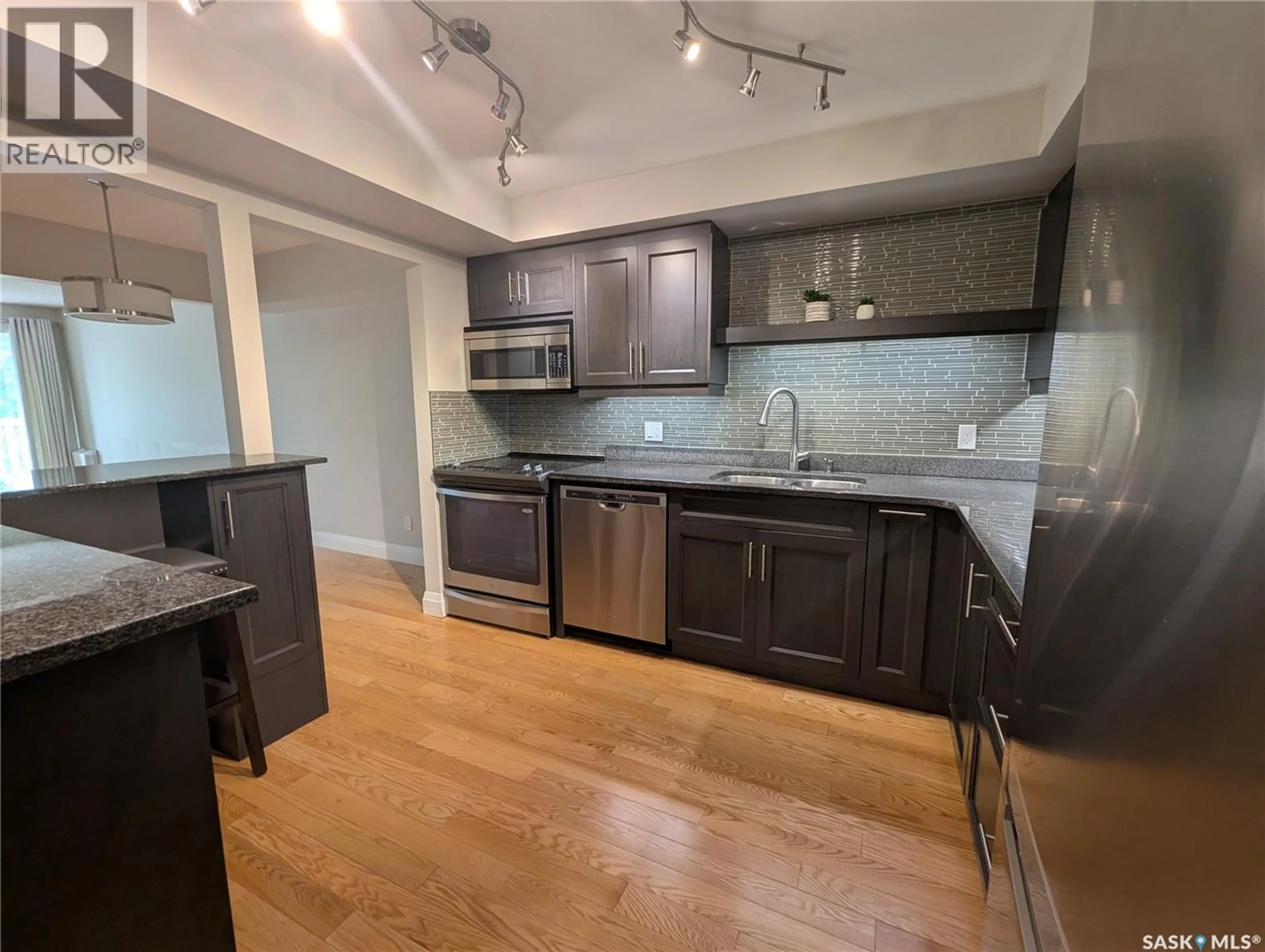 Open concept kitchen, wood/laminate floor for 204 - 921 MAIN STREET, Saskatoon Saskatchewan S7H0K5