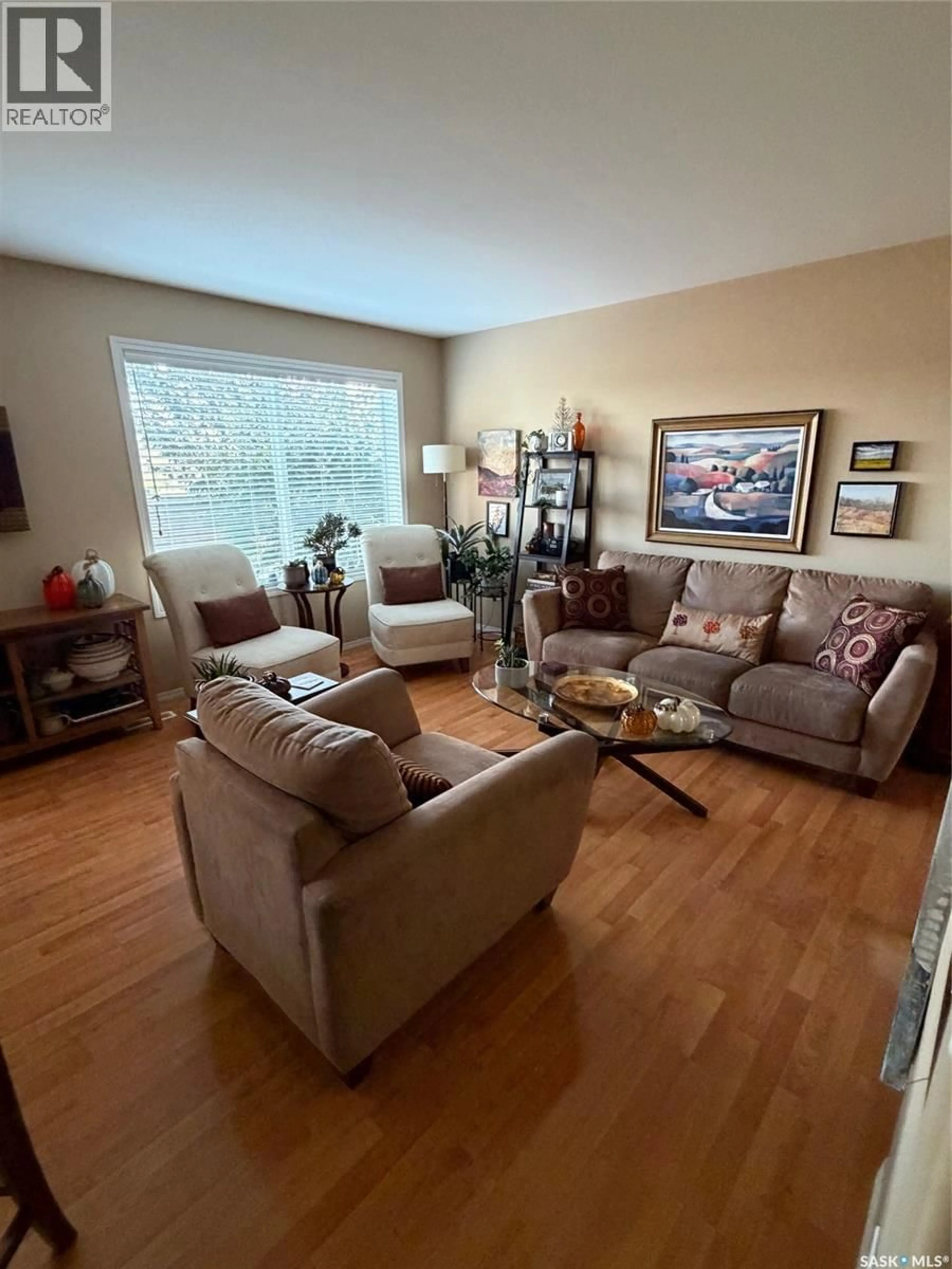 Living room with furniture, wood/laminate floor for 121 445 BAYFIELD CRESCENT, Saskatoon Saskatchewan S7V1J1