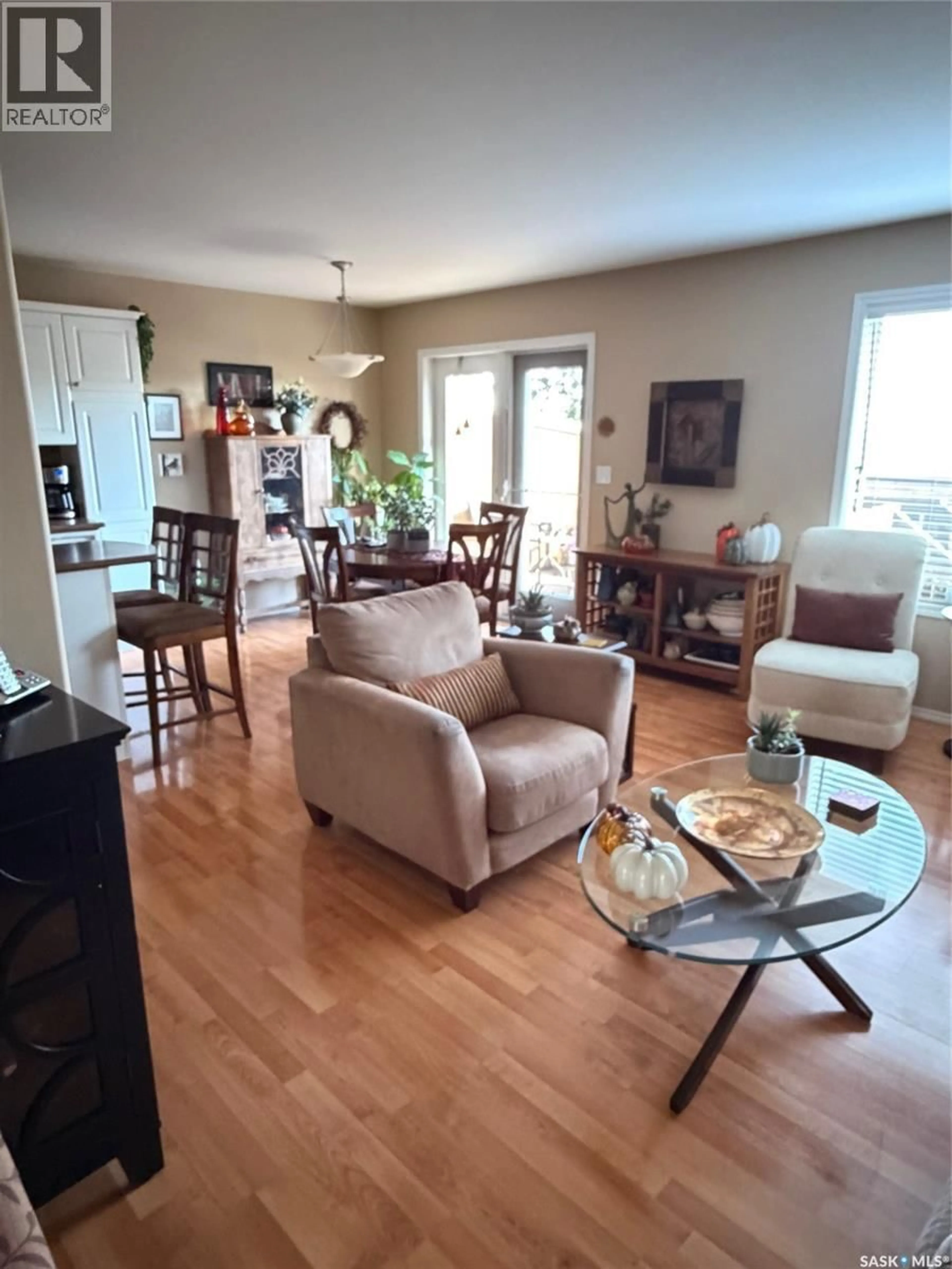 Living room with furniture, wood/laminate floor for 121 445 BAYFIELD CRESCENT, Saskatoon Saskatchewan S7V1J1