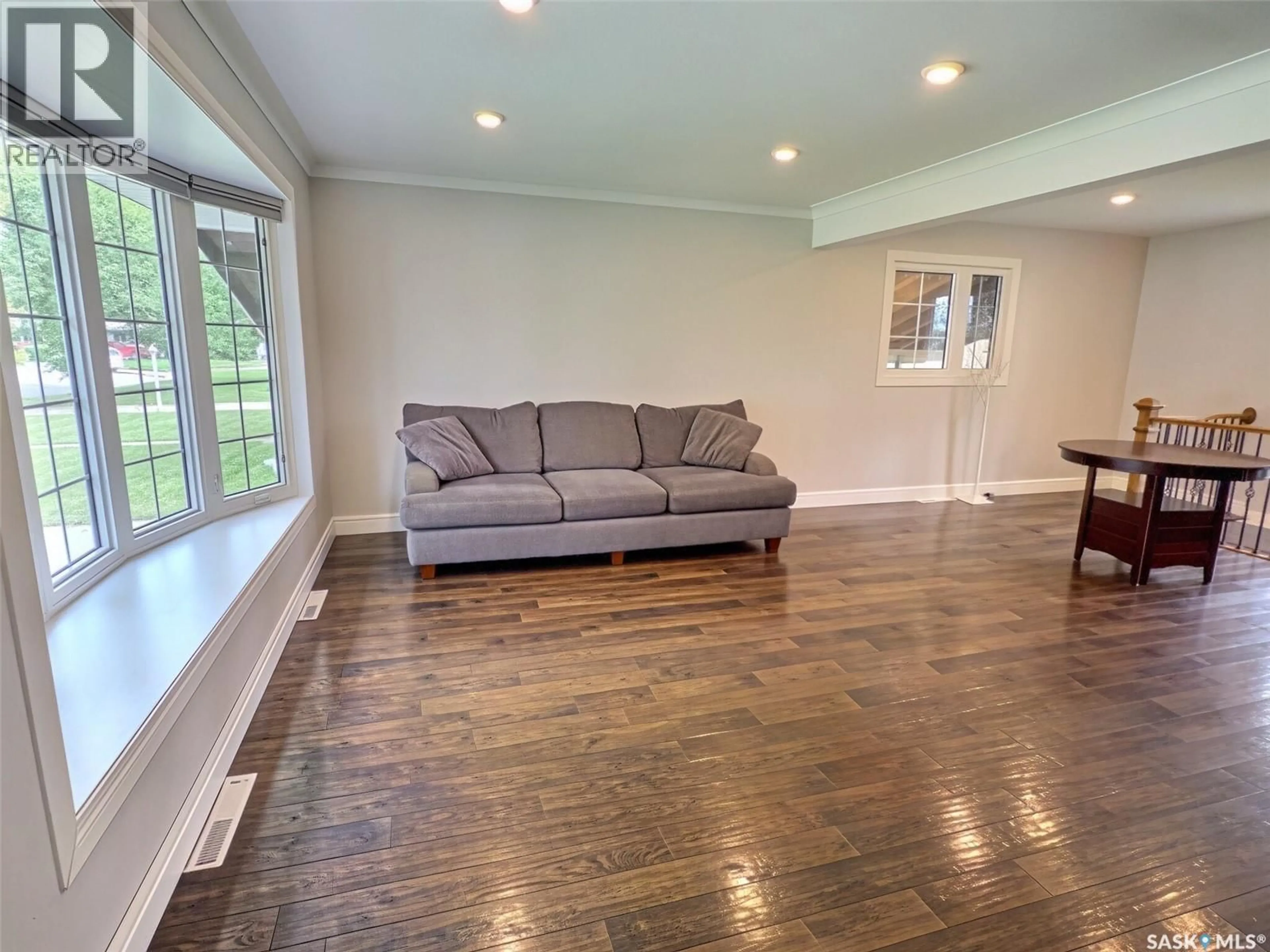 Living room with furniture, wood/laminate floor for 144 MCDONALD ROAD, Estevan Saskatchewan S4A0B8