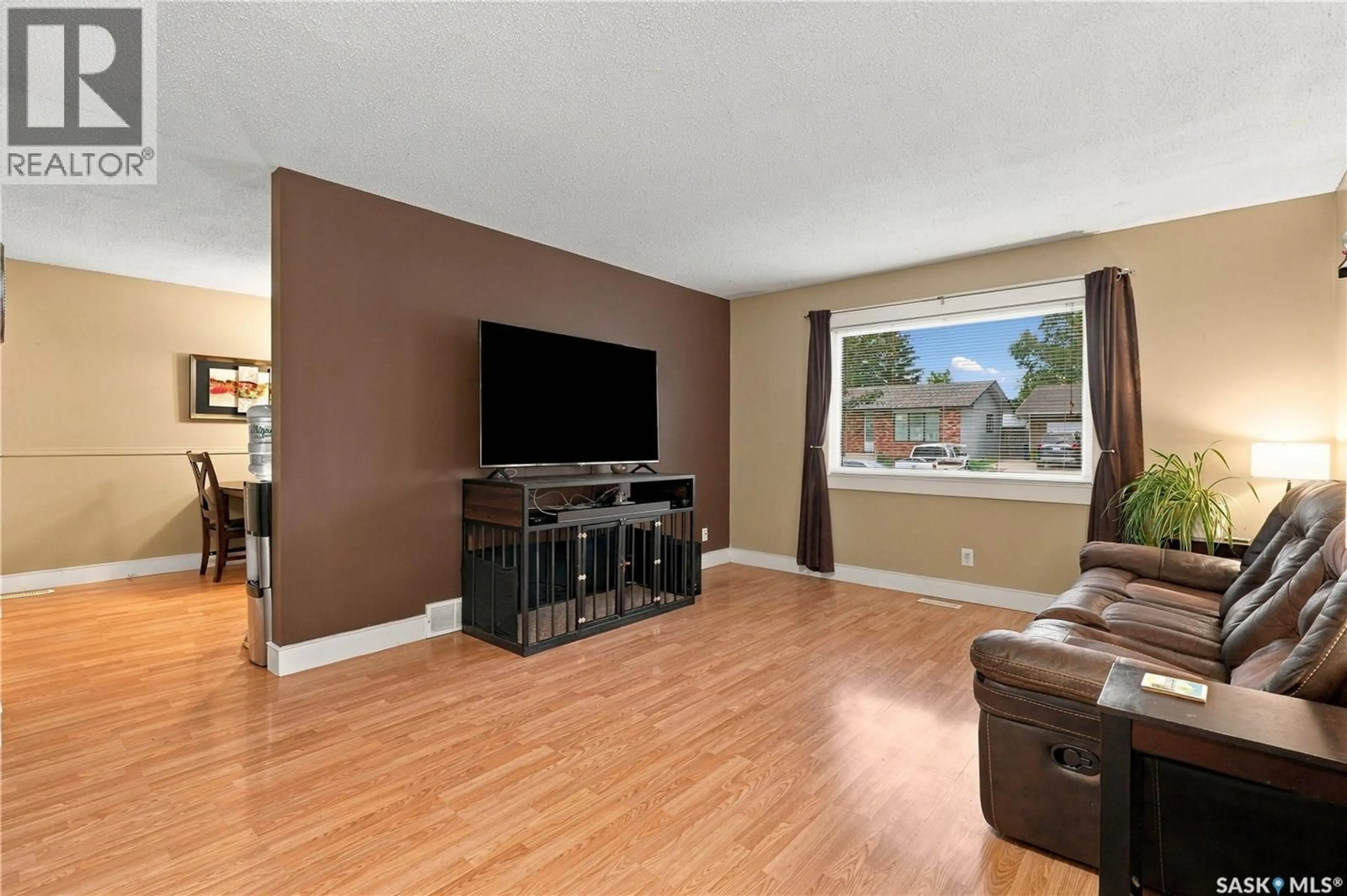 Living room with furniture, wood/laminate floor for 426 LANGEVIN CRESCENT, Saskatoon Saskatchewan S7L5R6