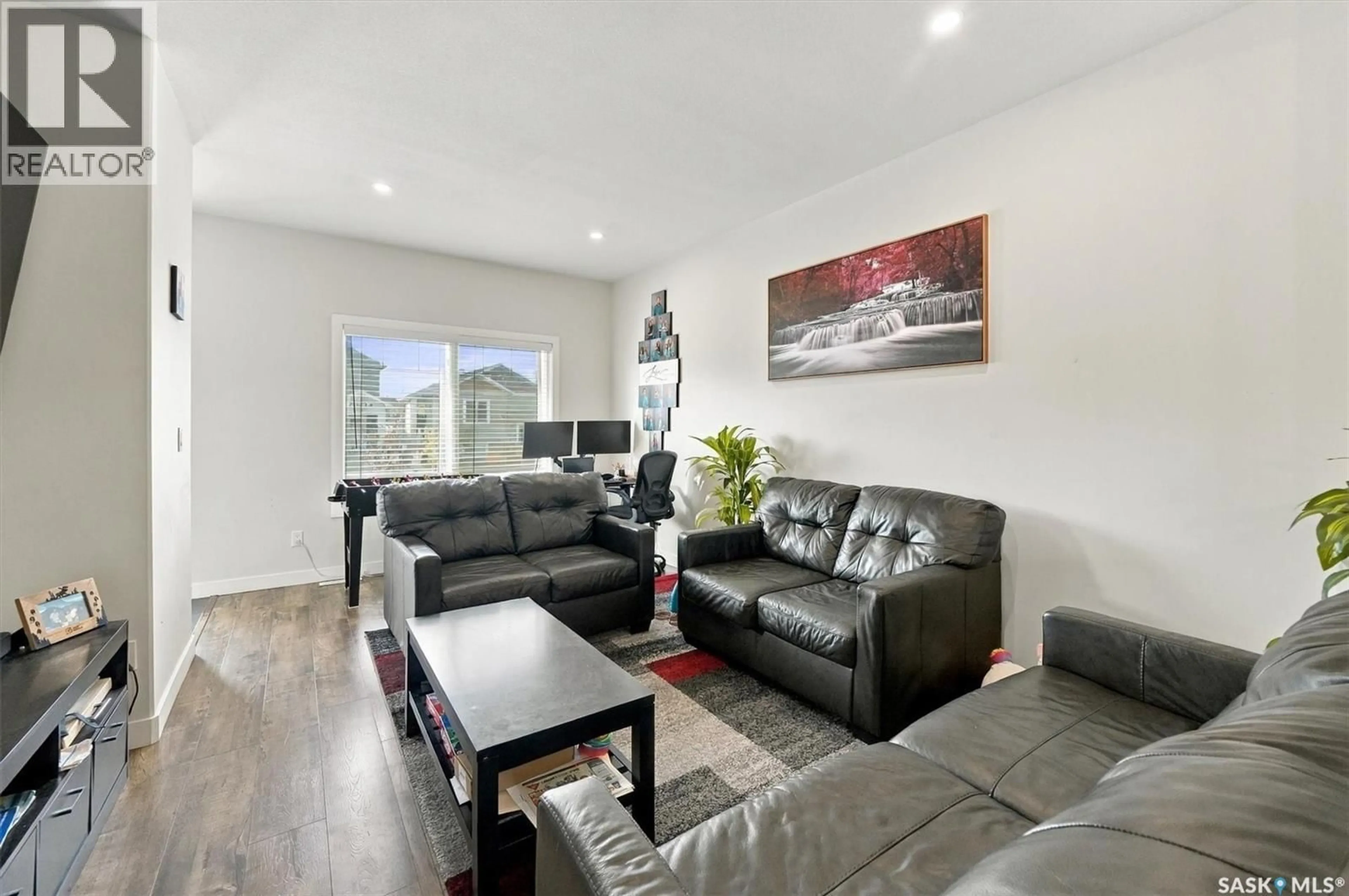 Living room with furniture, wood/laminate floor for 661 FEHEREGYHAZI BOULEVARD, Saskatoon Saskatchewan S7W0Z4
