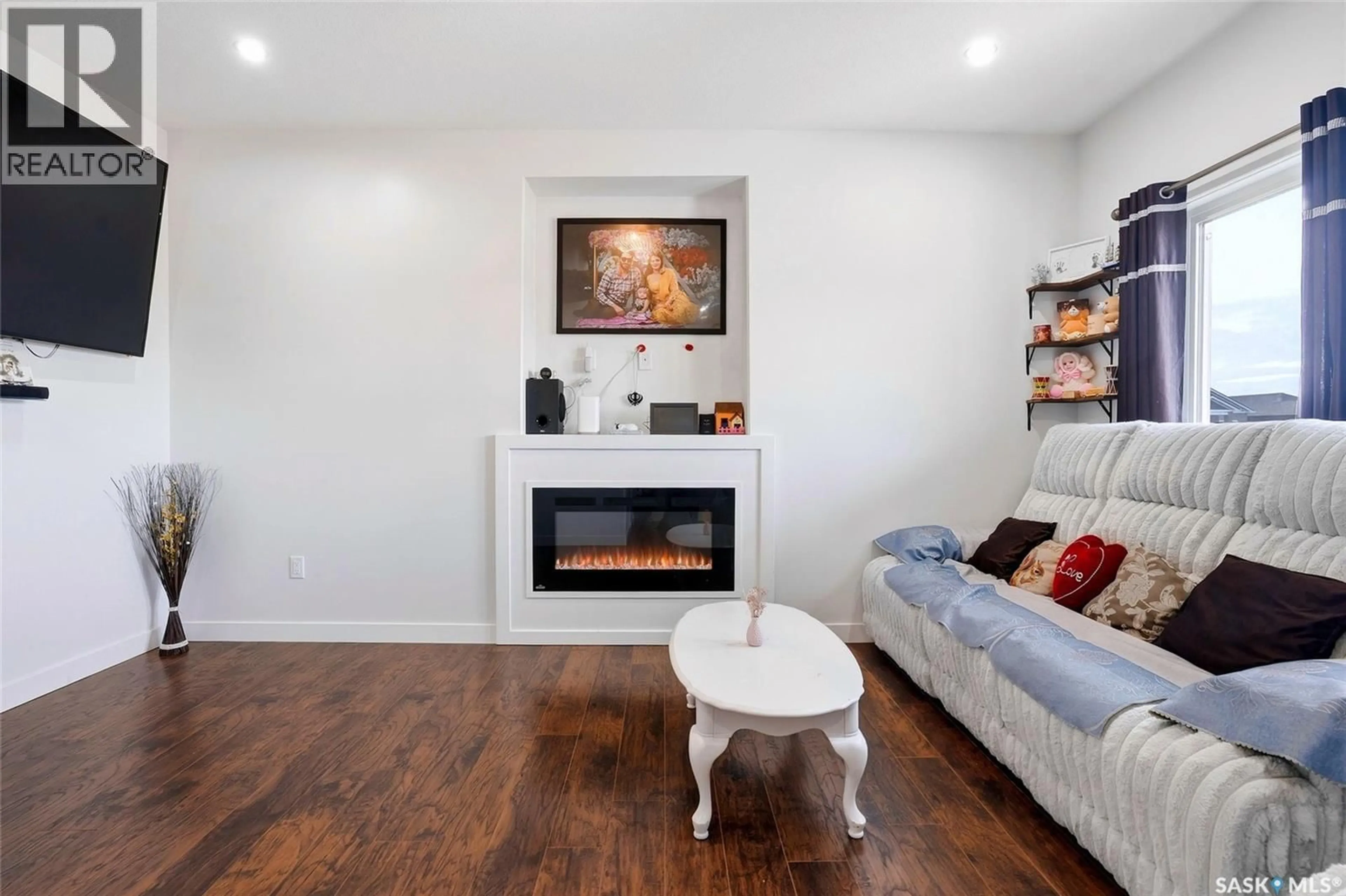 Living room with furniture, wood/laminate floor for 327 MCARTHUR CRESCENT, Saskatoon Saskatchewan S7L6X2
