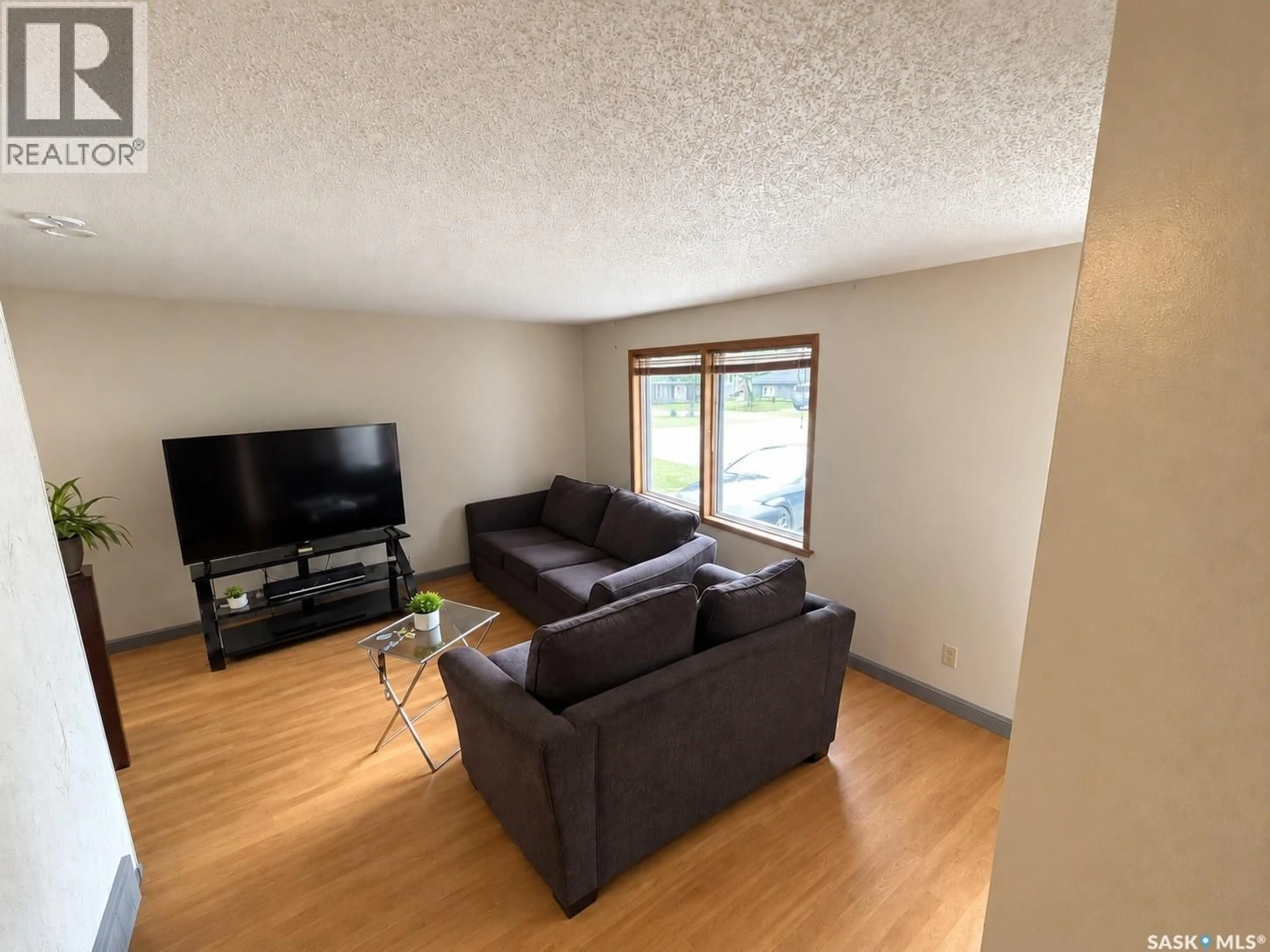 Living room with furniture, wood/laminate floor for 890 KINGSMERE BOULEVARD, Saskatoon Saskatchewan S7J4J7