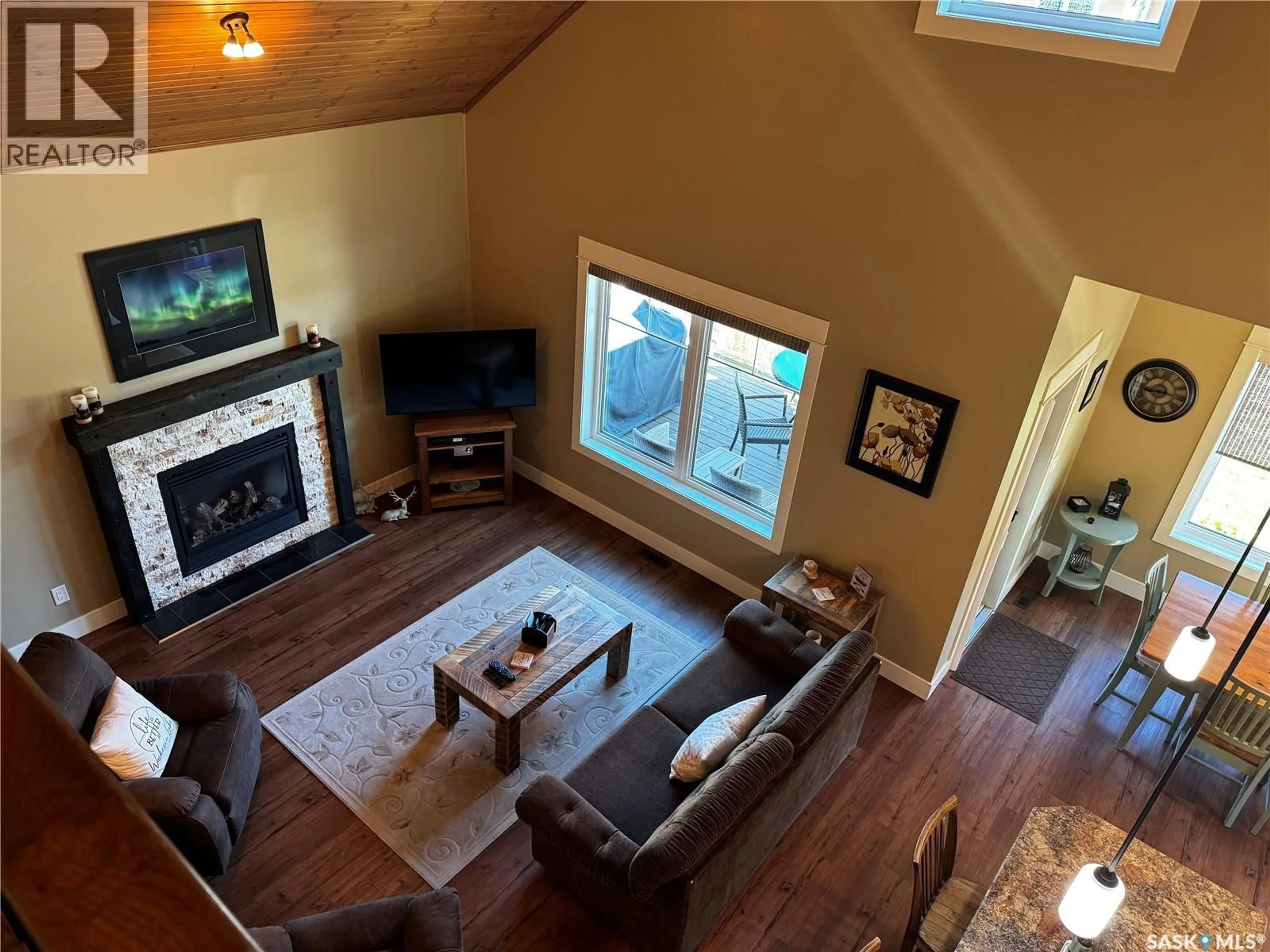 Living room with furniture, wood/laminate floor for 11 COTTAGE CRESCENT, Elk Ridge Saskatchewan S0J2Y0
