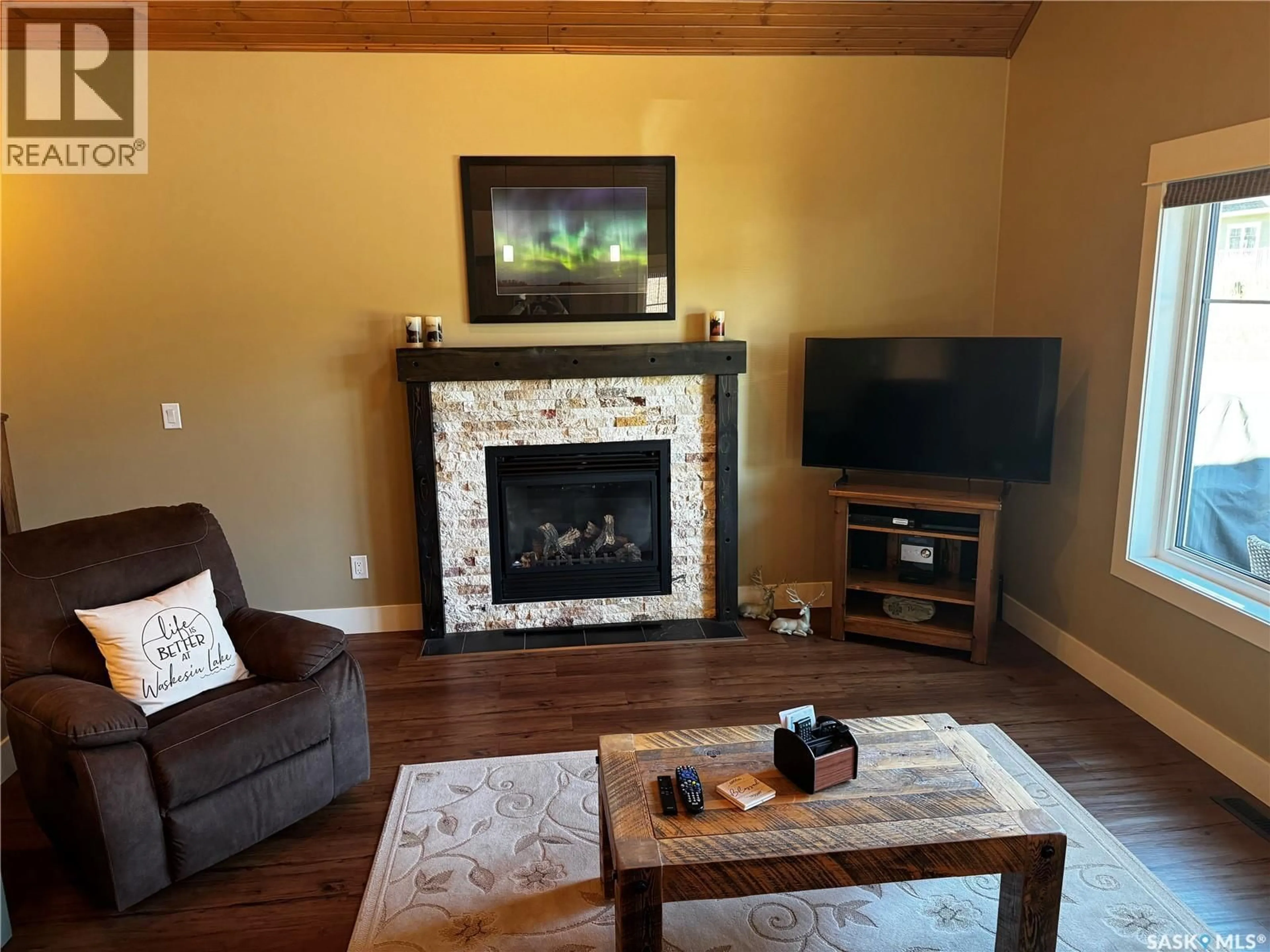 Living room with furniture, wood/laminate floor for 11 COTTAGE CRESCENT, Elk Ridge Saskatchewan S0J2Y0