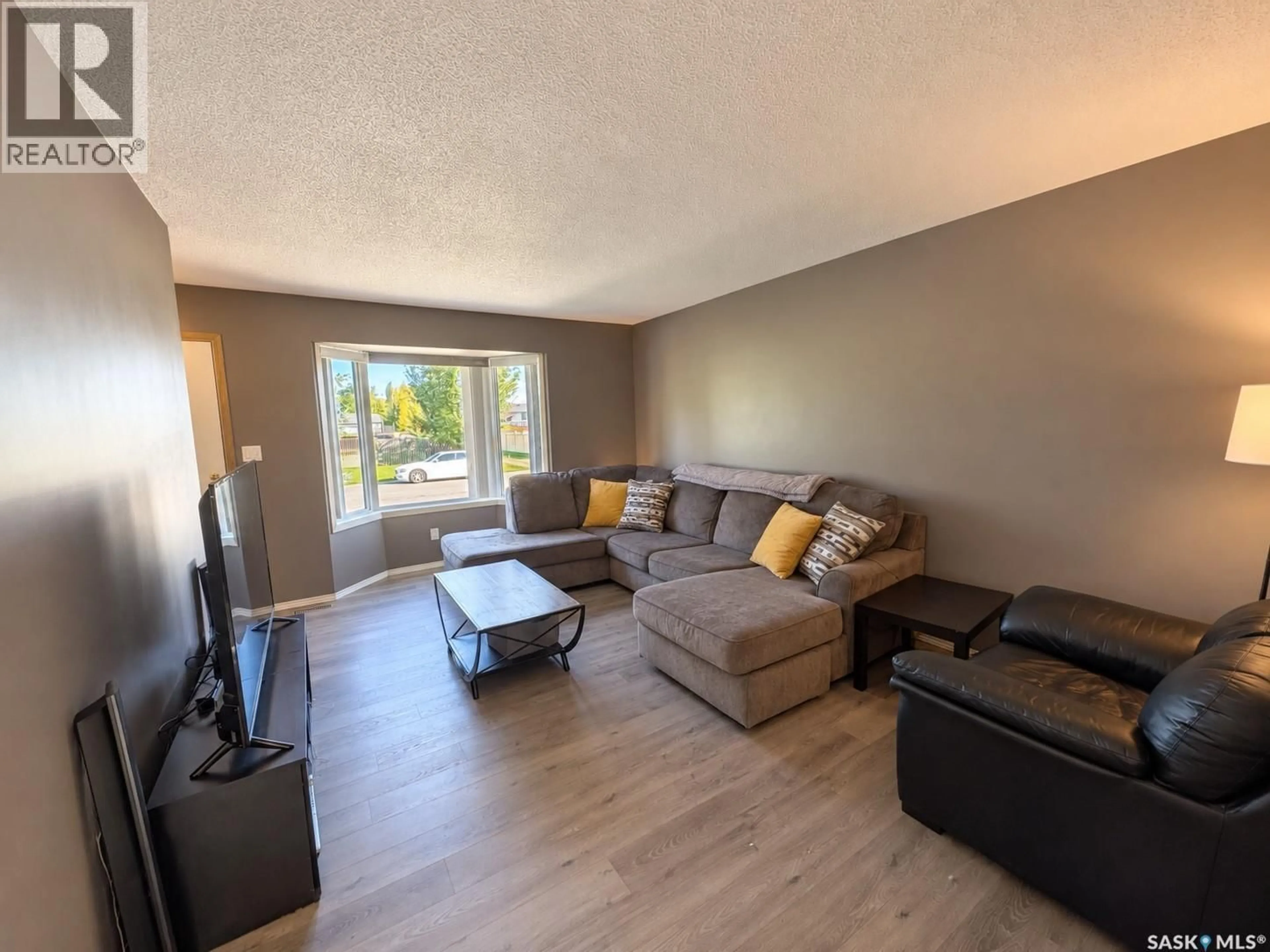 Living room with furniture, wood/laminate floor for 77 3RD STREET, Humboldt Saskatchewan S0K2A0