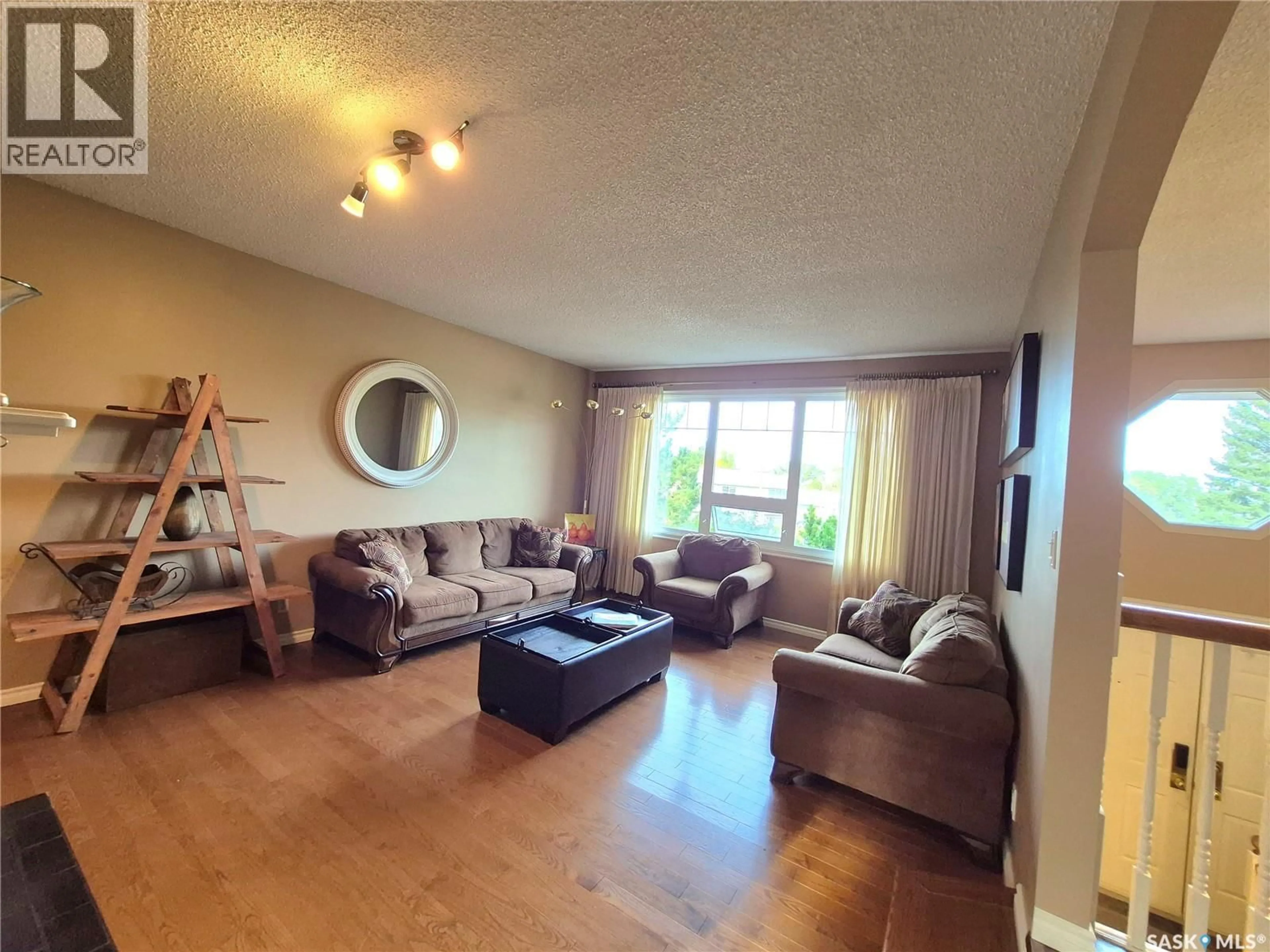 Living room with furniture, wood/laminate floor for 280 HAYES DRIVE, Swift Current Saskatchewan S9H4H1