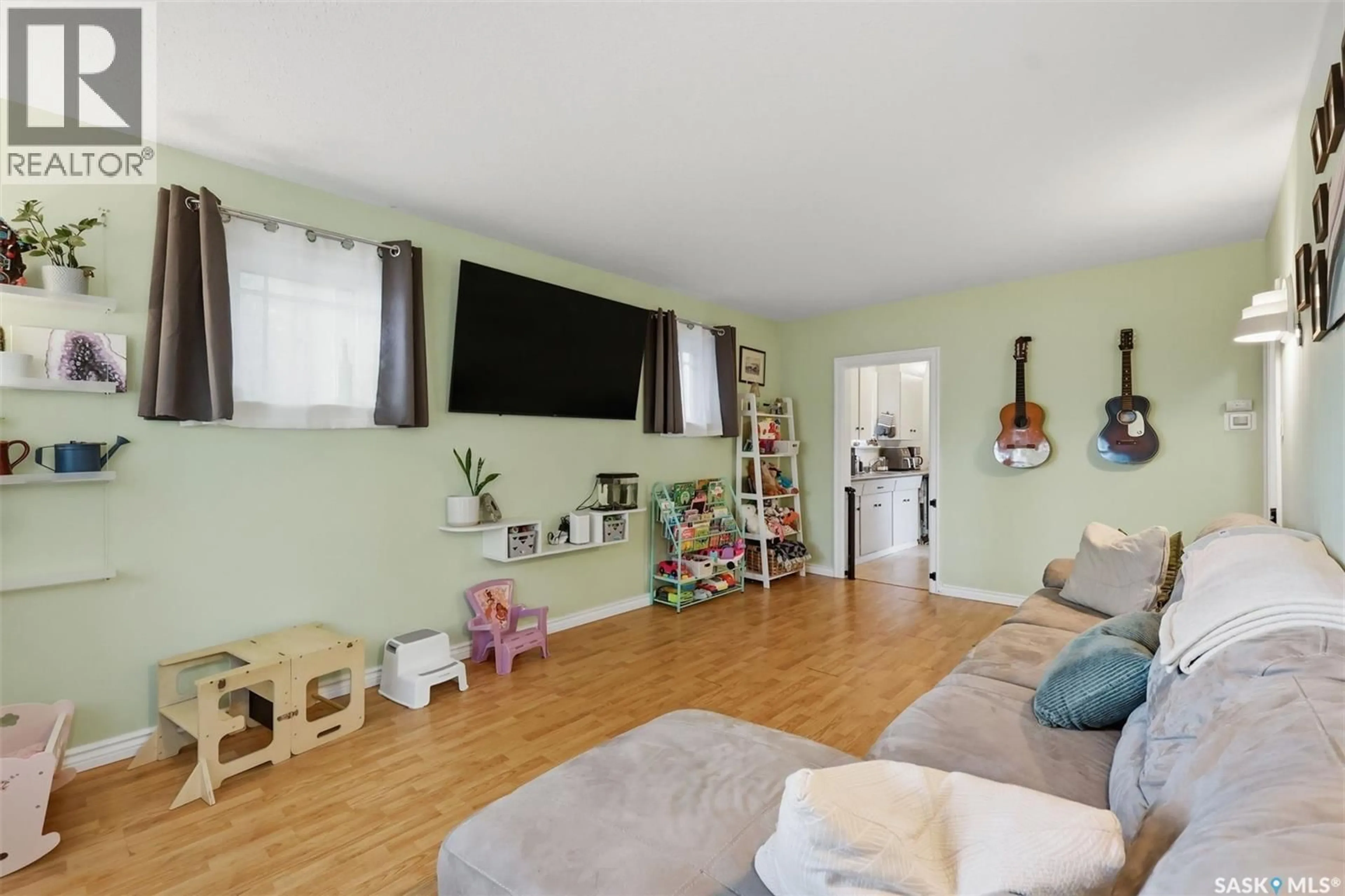 Living room with furniture, wood/laminate floor for 115 ASH STREET, Saskatoon Saskatchewan S7J0J7