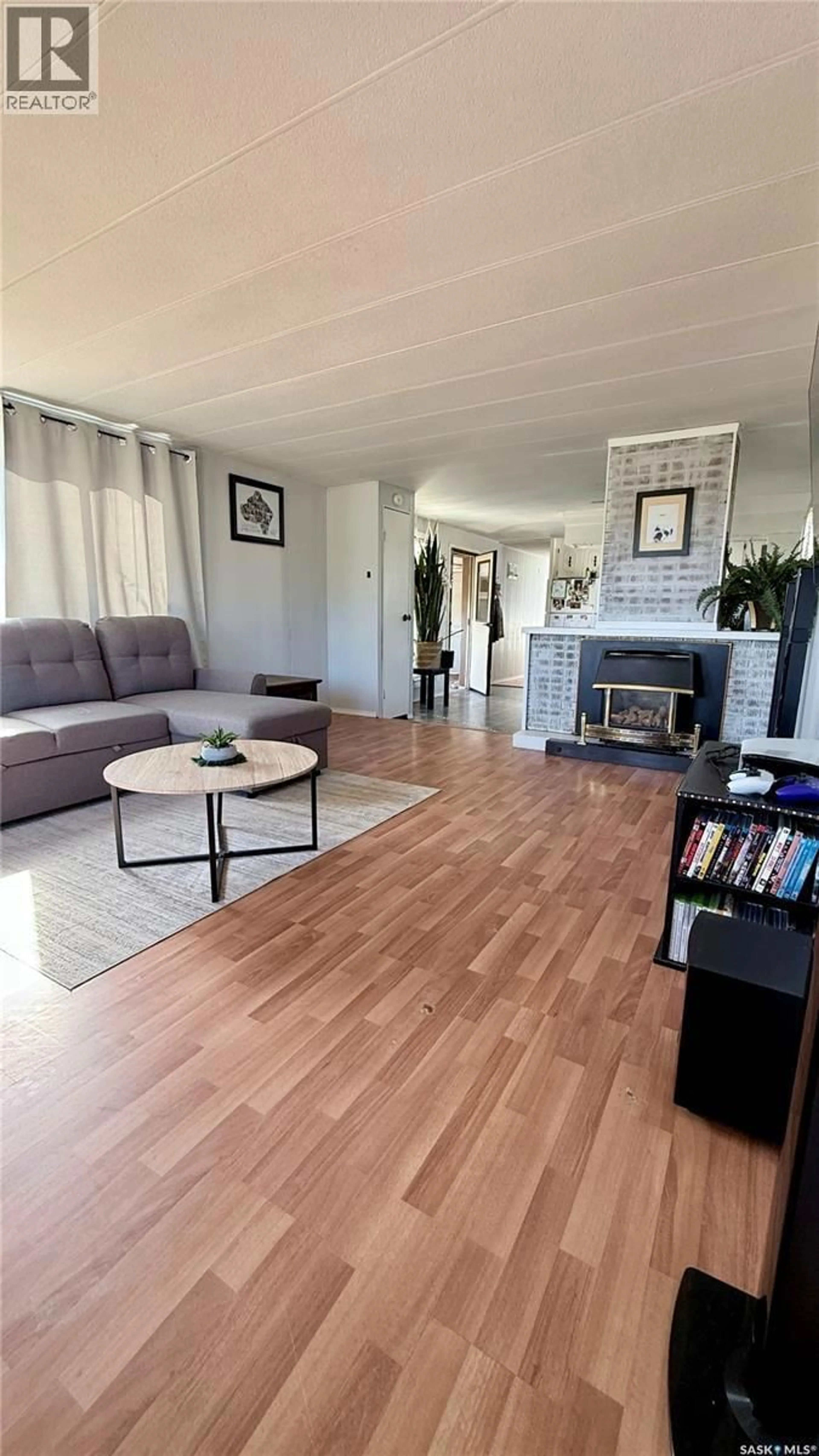 Living room with furniture, wood/laminate floor for 460 WILLOW PARK GREENS, Estevan Saskatchewan S4A2S2