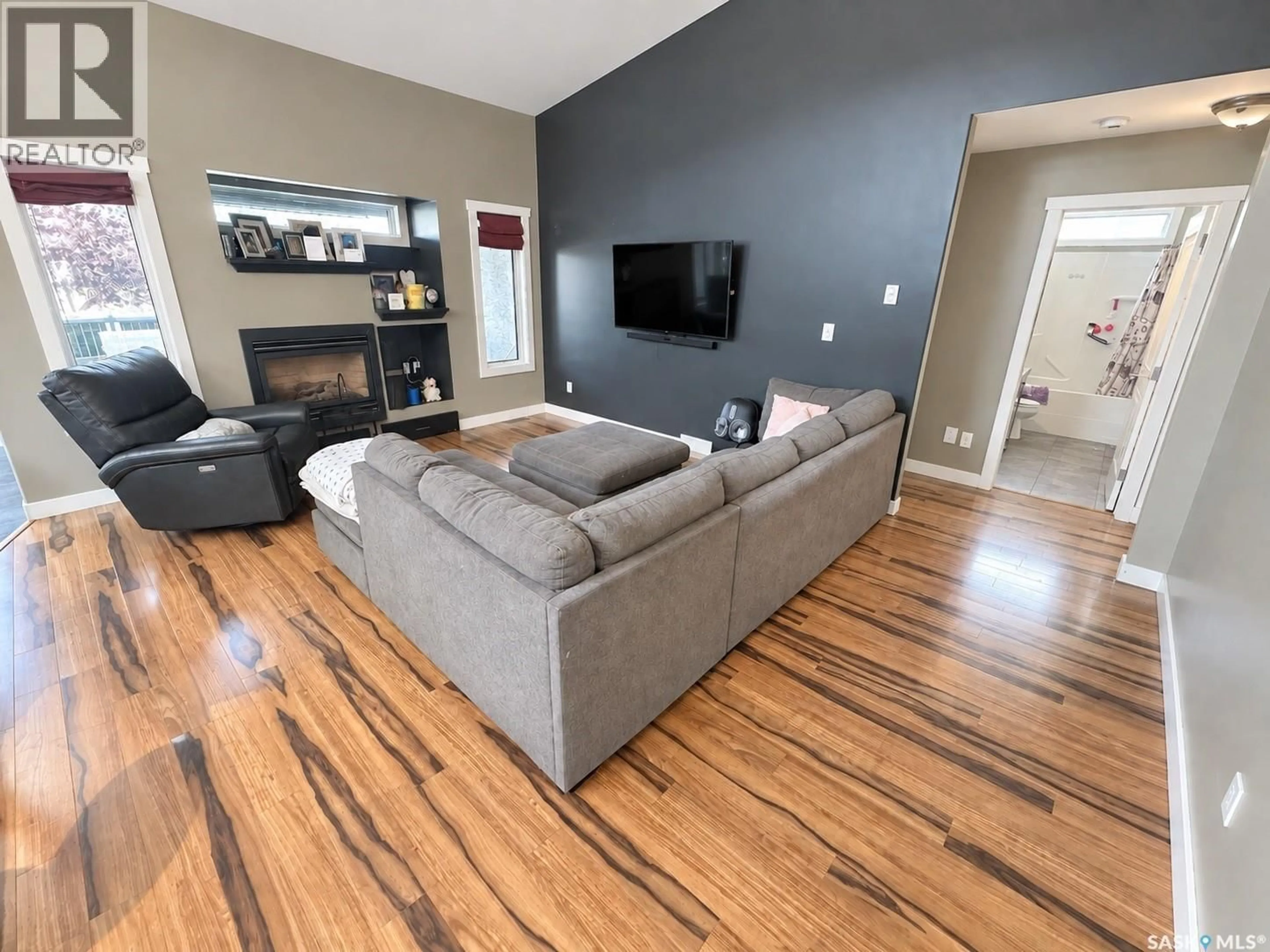 Living room with furniture, wood/laminate floor for 715 18TH STREET, Weyburn Saskatchewan S4H3M2