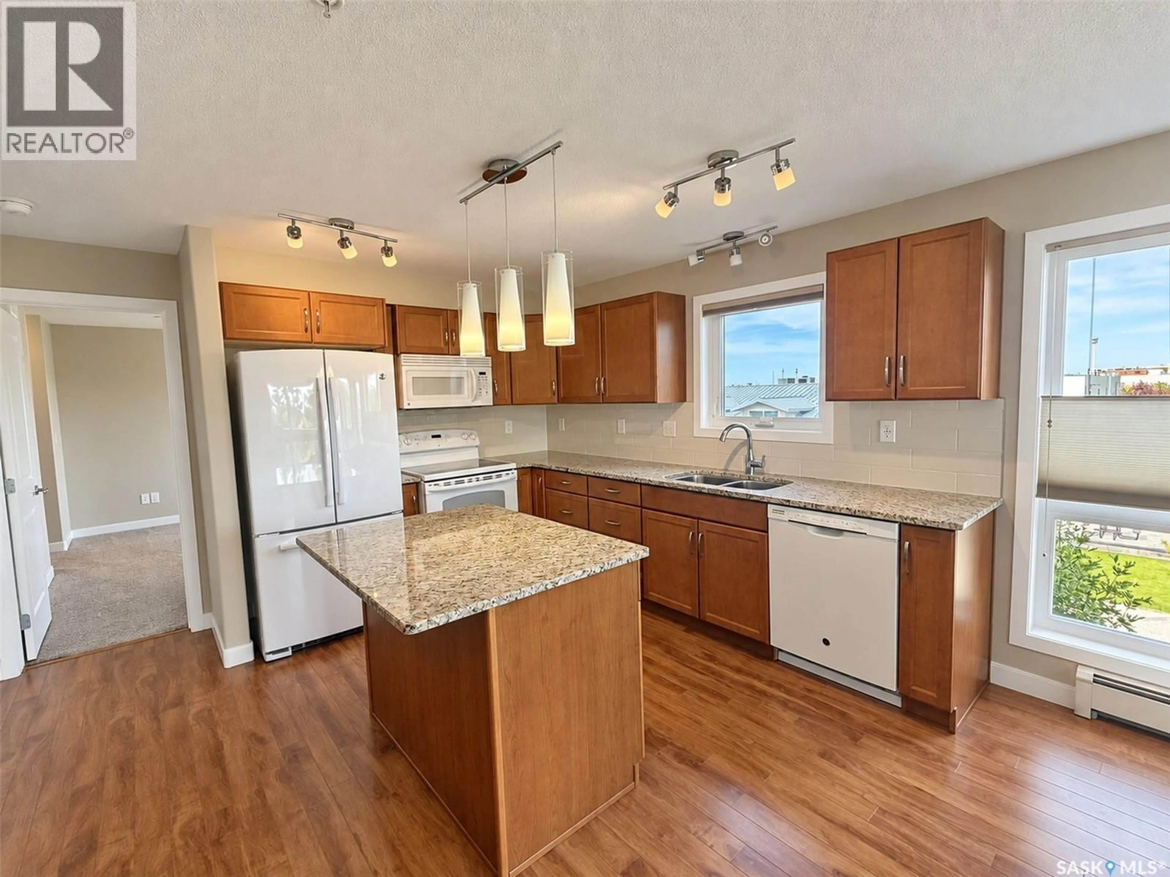 Open concept kitchen, wood/laminate floor for 205 - 2311 WINDSOR PARK ROAD, Regina Saskatchewan S4V1S2