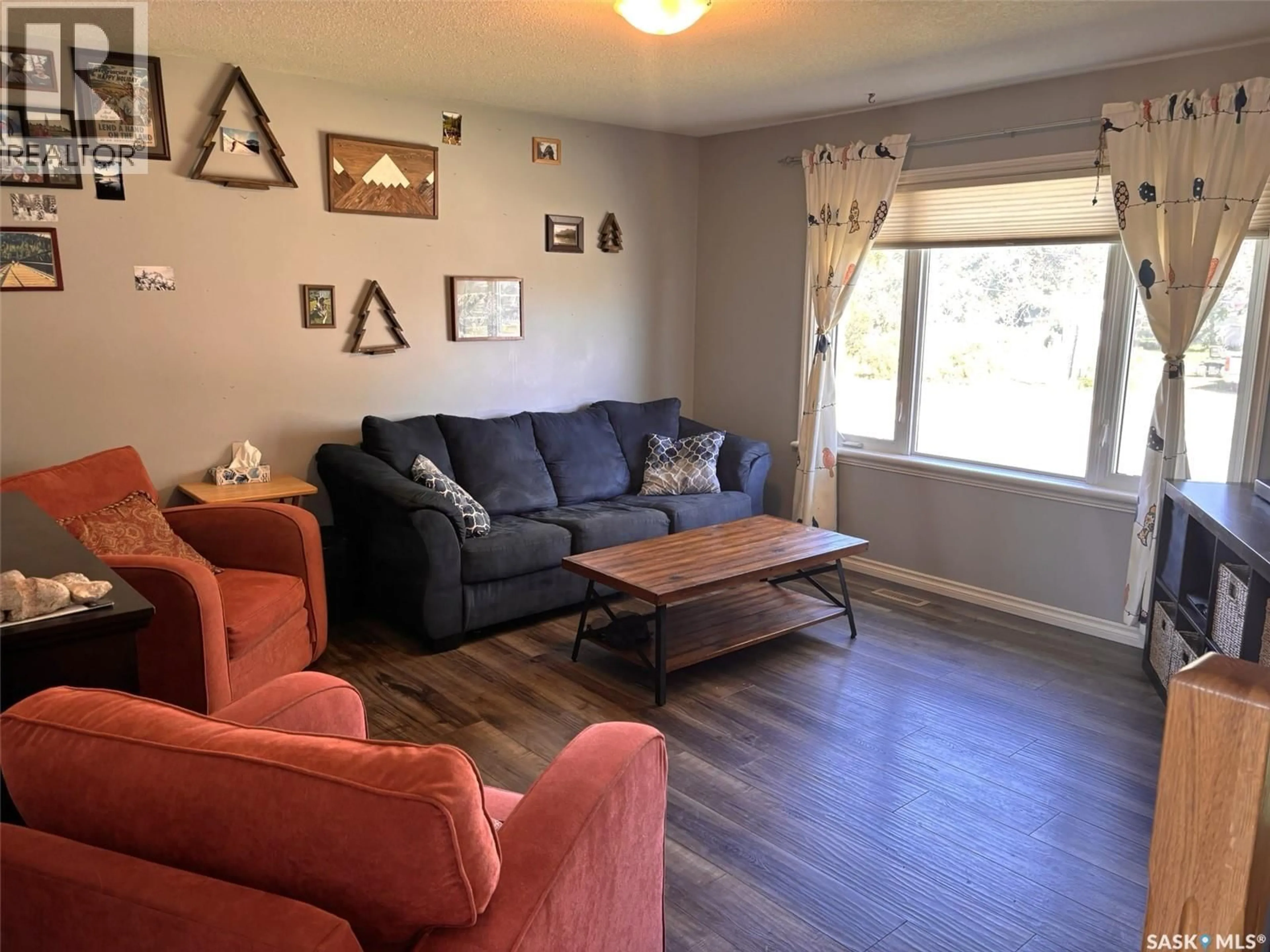 Living room with furniture, wood/laminate floor for 702 2ND STREET, Hanley Saskatchewan S0G2E0