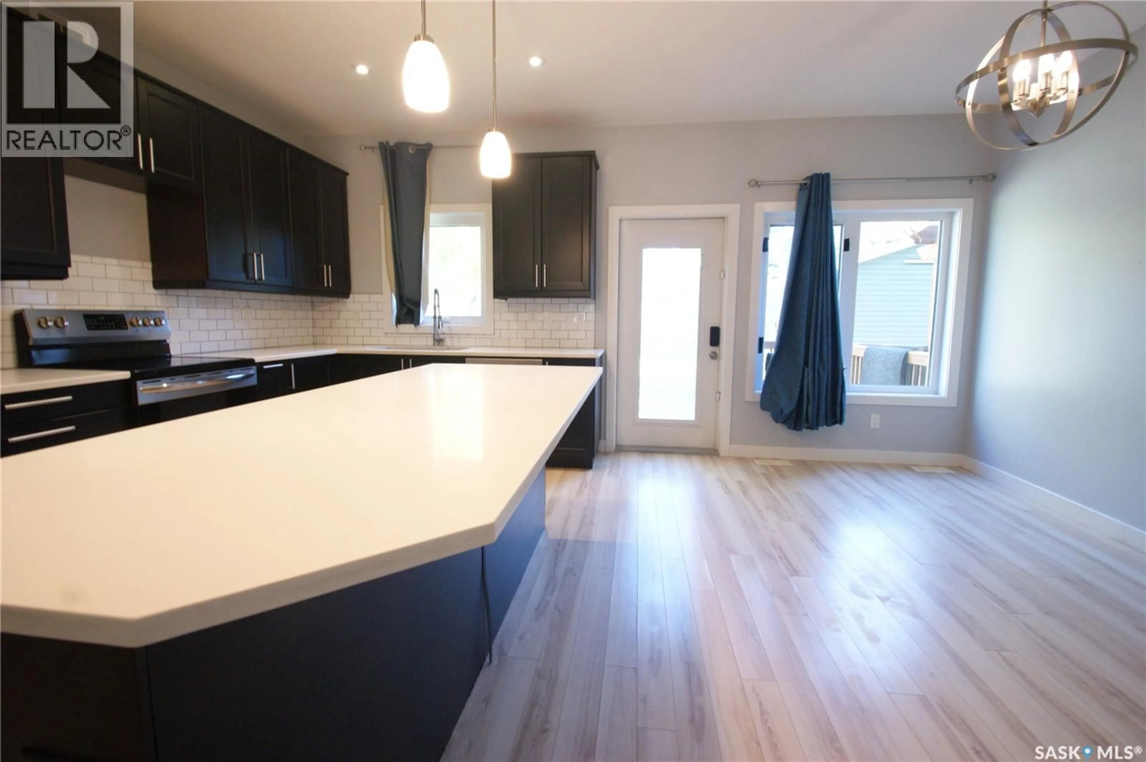 Open concept kitchen, wood/laminate floor for 1303A BROADWAY AVENUE, Saskatoon Saskatchewan S7H2A5