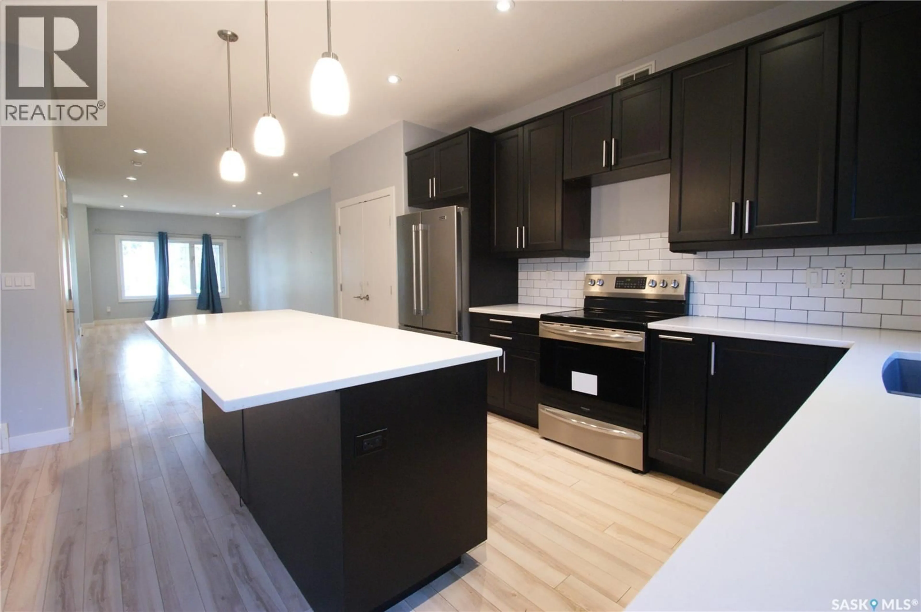 Open concept kitchen, wood/laminate floor for 1303A BROADWAY AVENUE, Saskatoon Saskatchewan S7H2A5