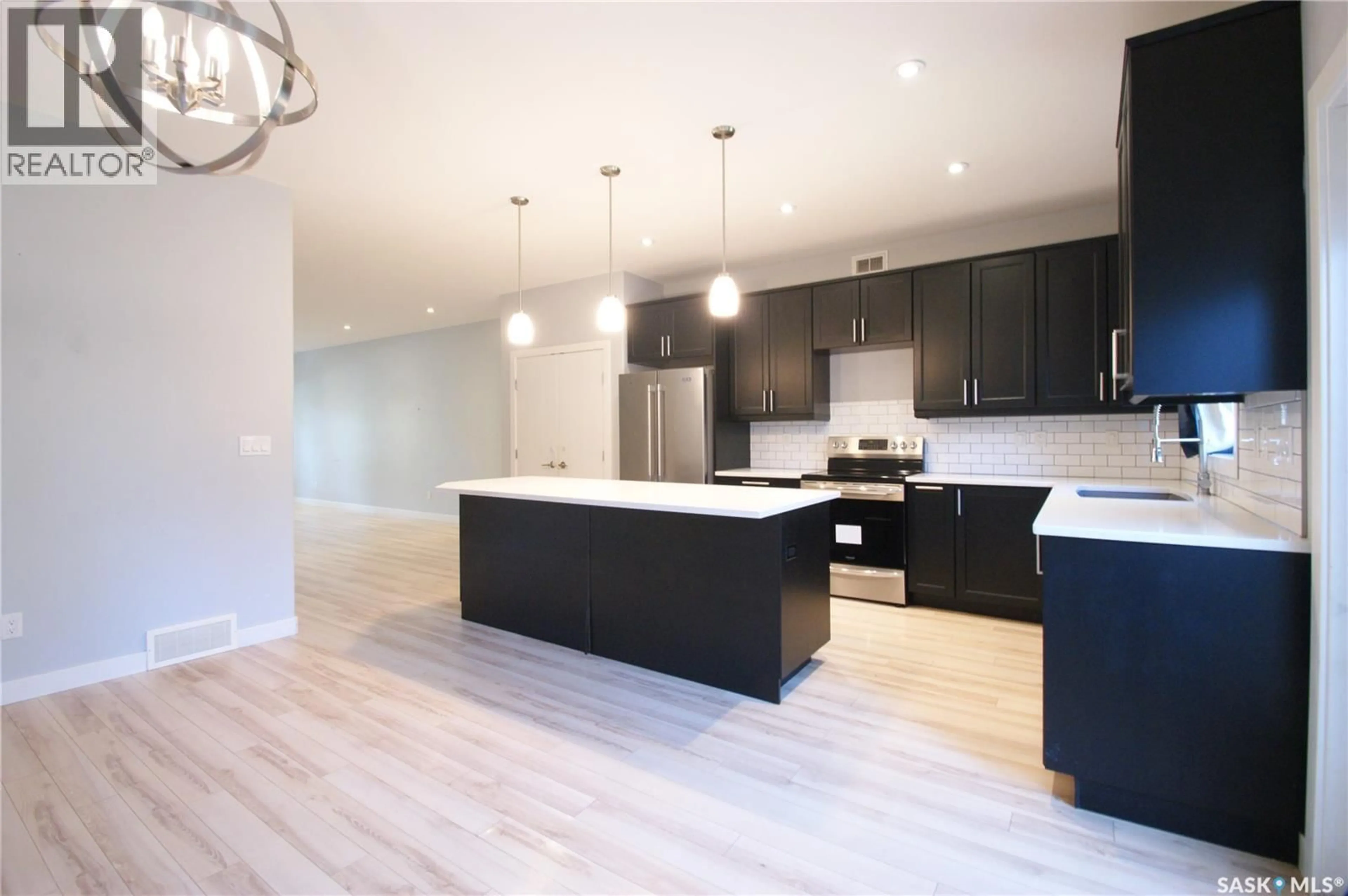Open concept kitchen, wood/laminate floor for 1303A BROADWAY AVENUE, Saskatoon Saskatchewan S7H2A5