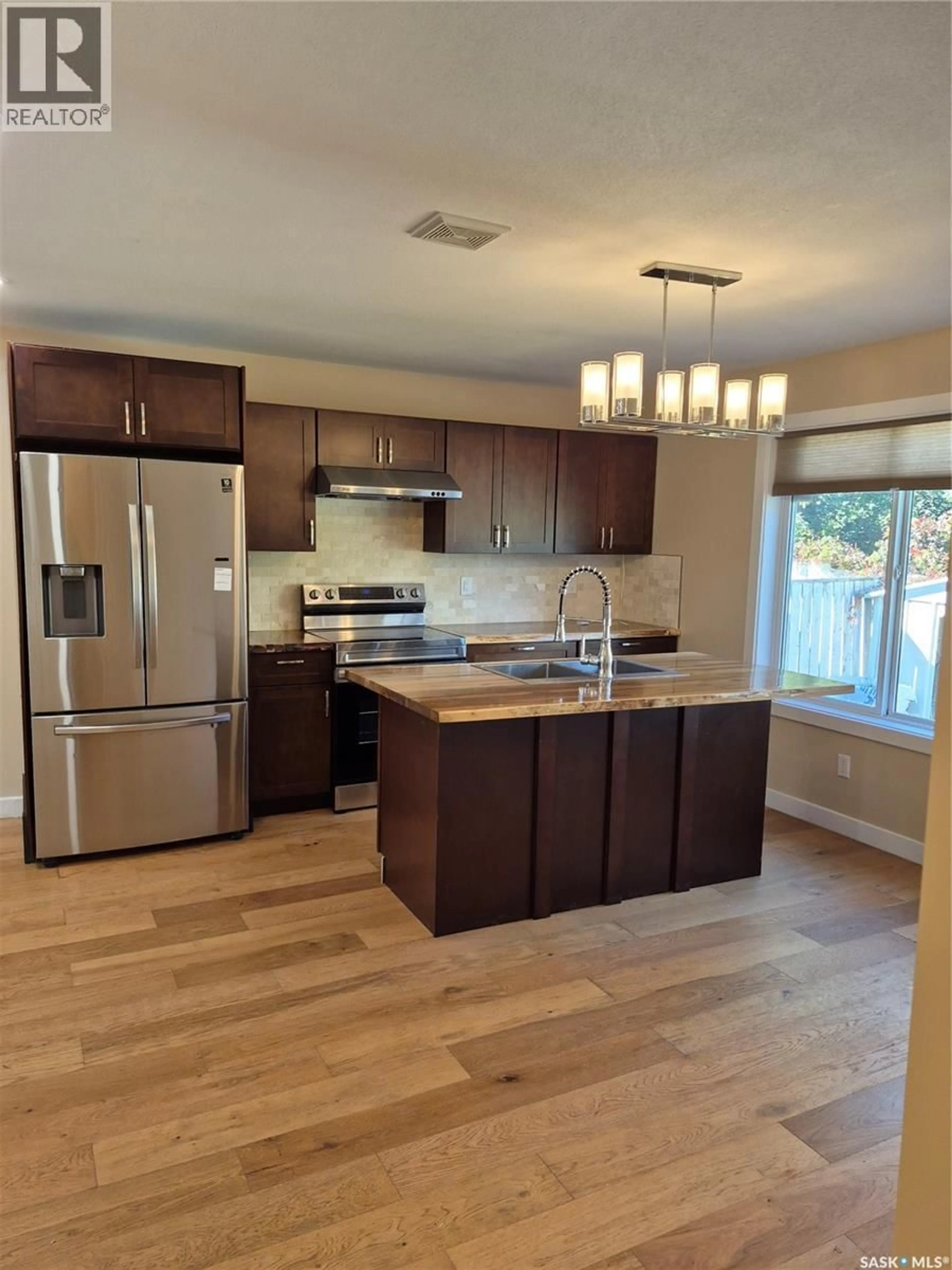 Open concept kitchen, wood/laminate floor for 21 143 GROPPER CRESCENT, Saskatoon Saskatchewan S7M5W2