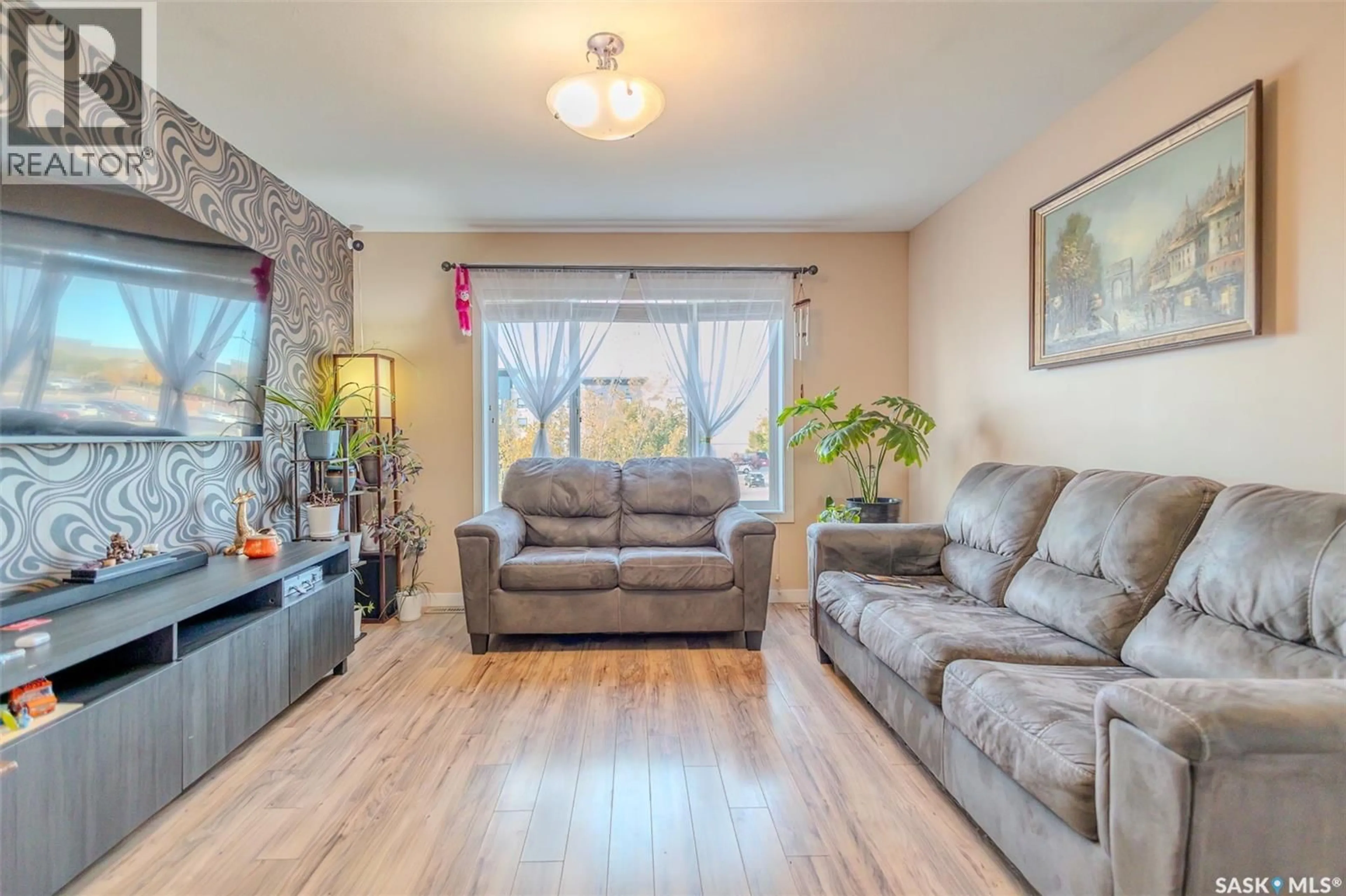 Living room with furniture, wood/laminate floor for 31 5004 JAMES HILL ROAD, Regina Saskatchewan S4W0E8