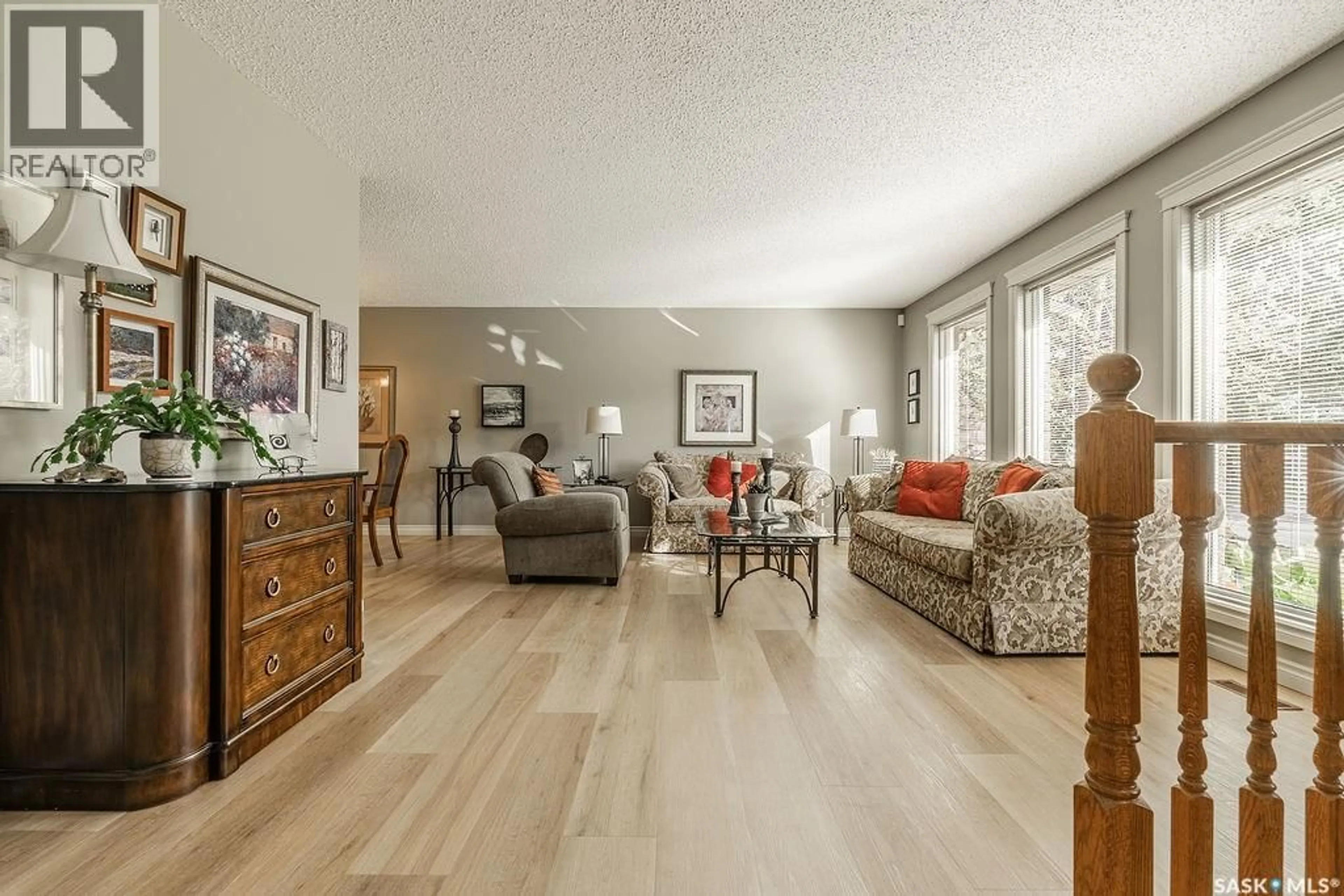 Living room with furniture, wood/laminate floor for 122 WAKAW CRESCENT, Saskatoon Saskatchewan S7J4E2