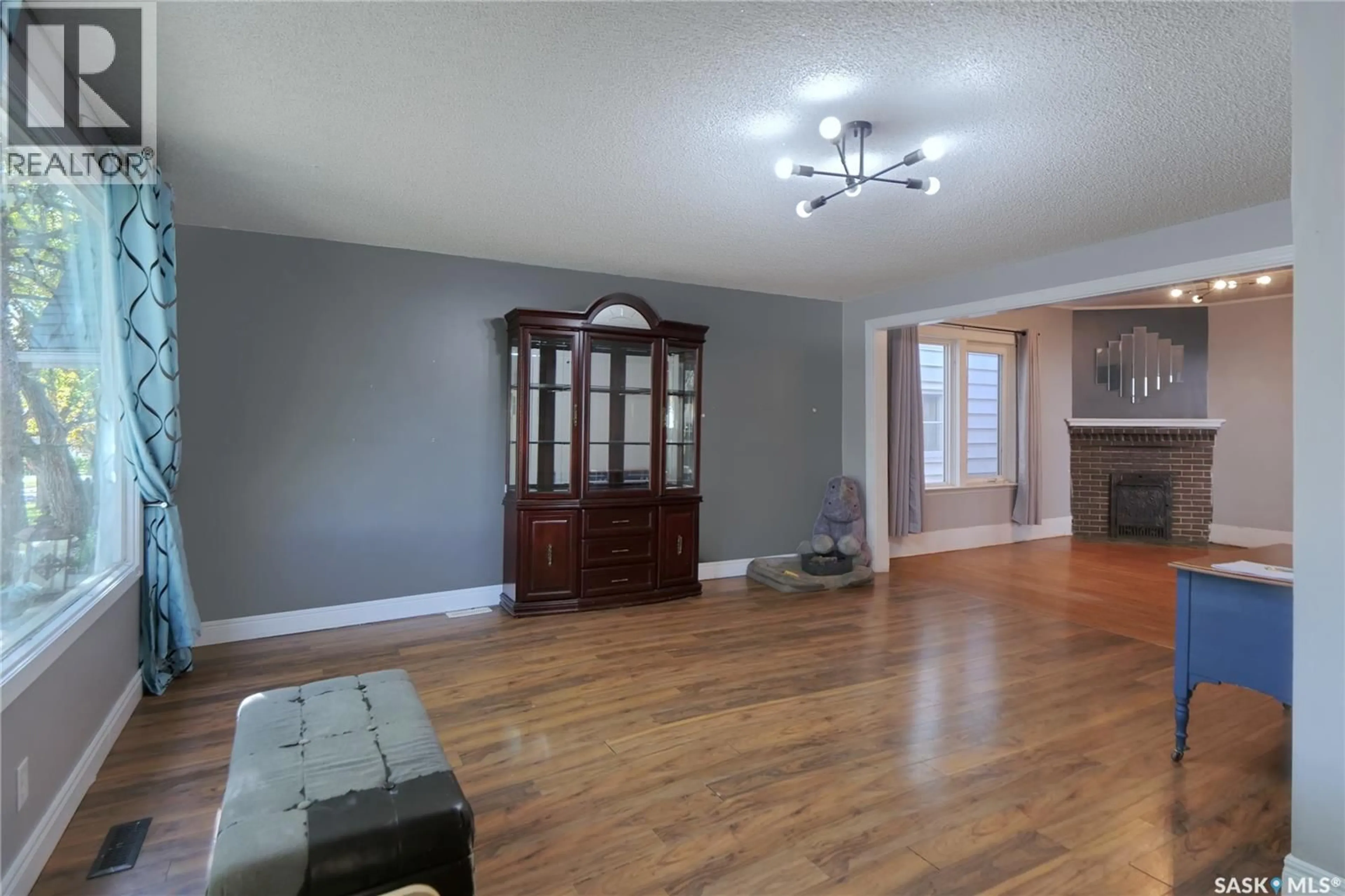 Living room with furniture, wood/laminate floor for 1042 ALGOMA AVENUE, Moose Jaw Saskatchewan S6H3Z5