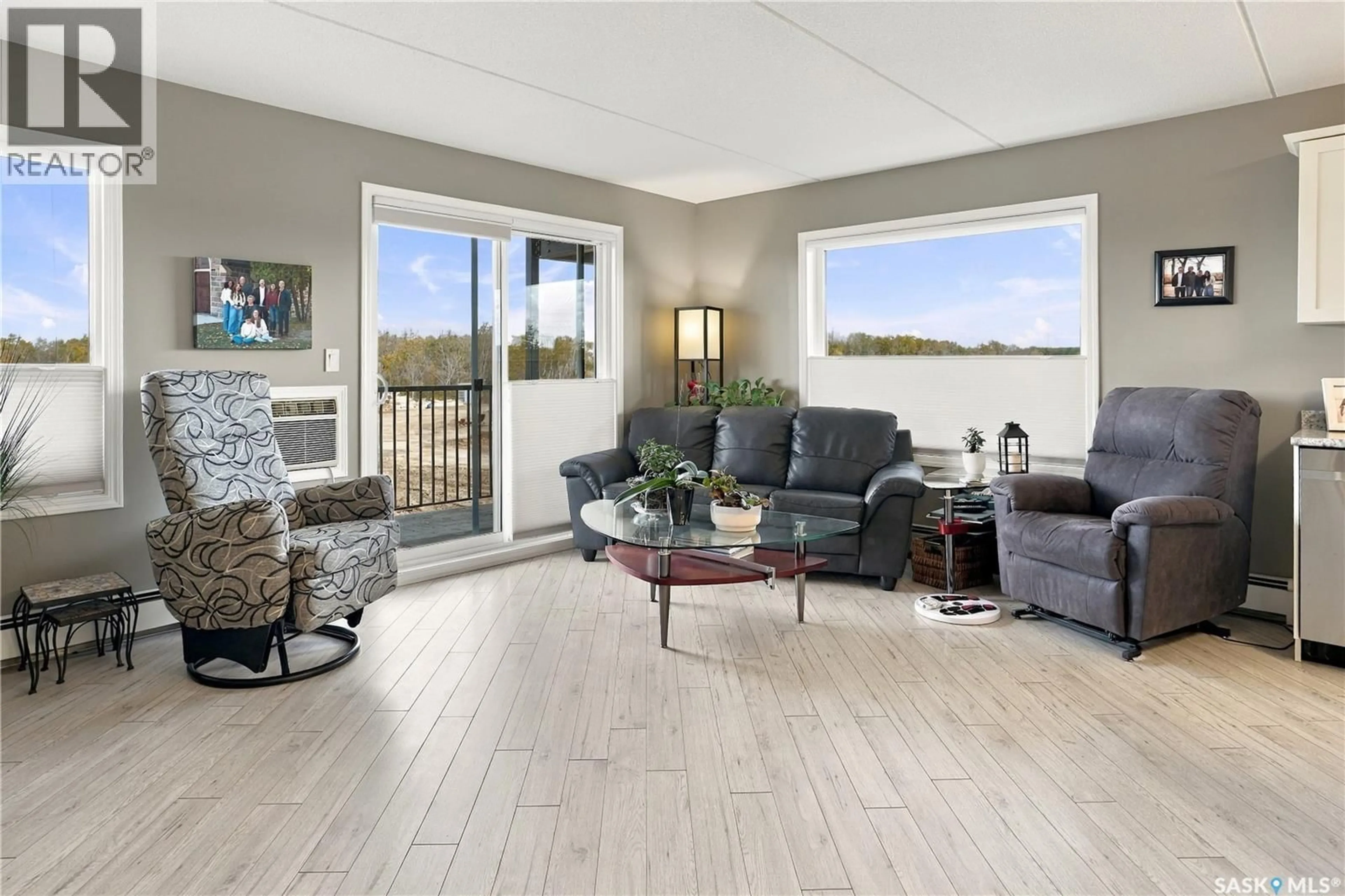 Living room with furniture, wood/laminate floor for 203 - 2426 BUHLER AVENUE, North Battleford Saskatchewan S9A1R5
