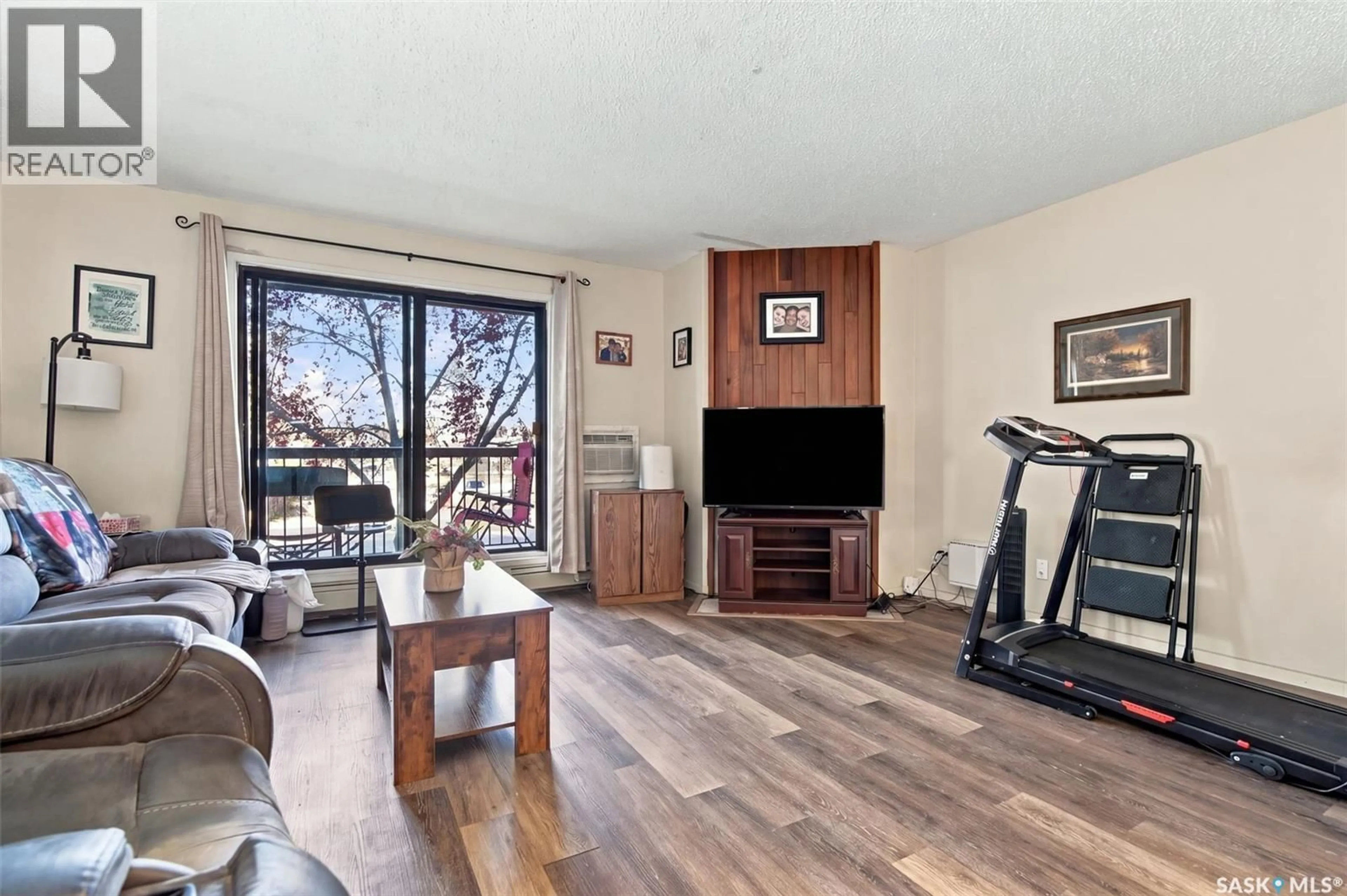 Living room with furniture, wood/laminate floor for 202 275 KINGSMERE BOULEVARD, Saskatoon Saskatchewan S7J4J6