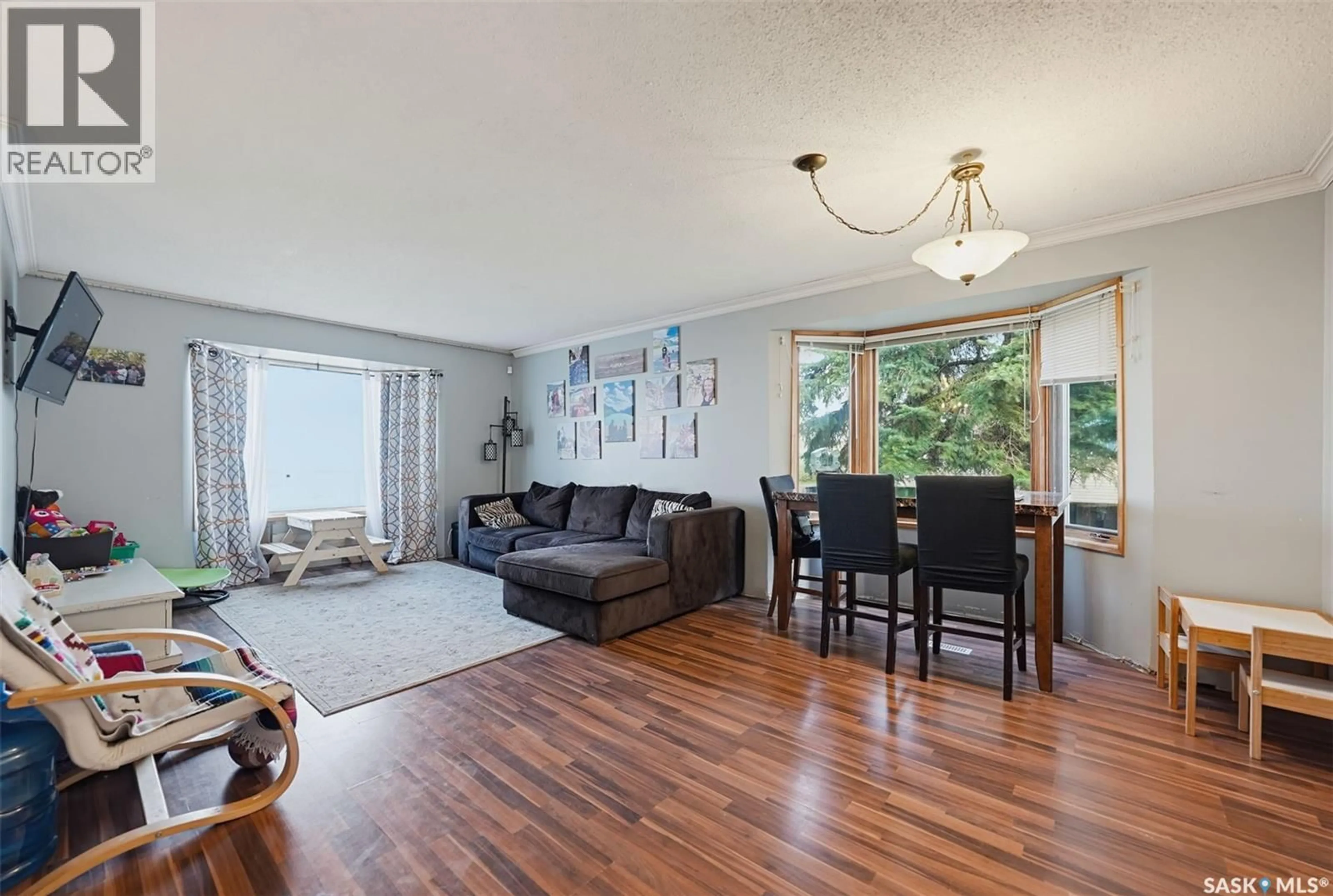 Living room with furniture, wood/laminate floor for 219 HAWKINS STREET, Drake Saskatchewan S0K1H0