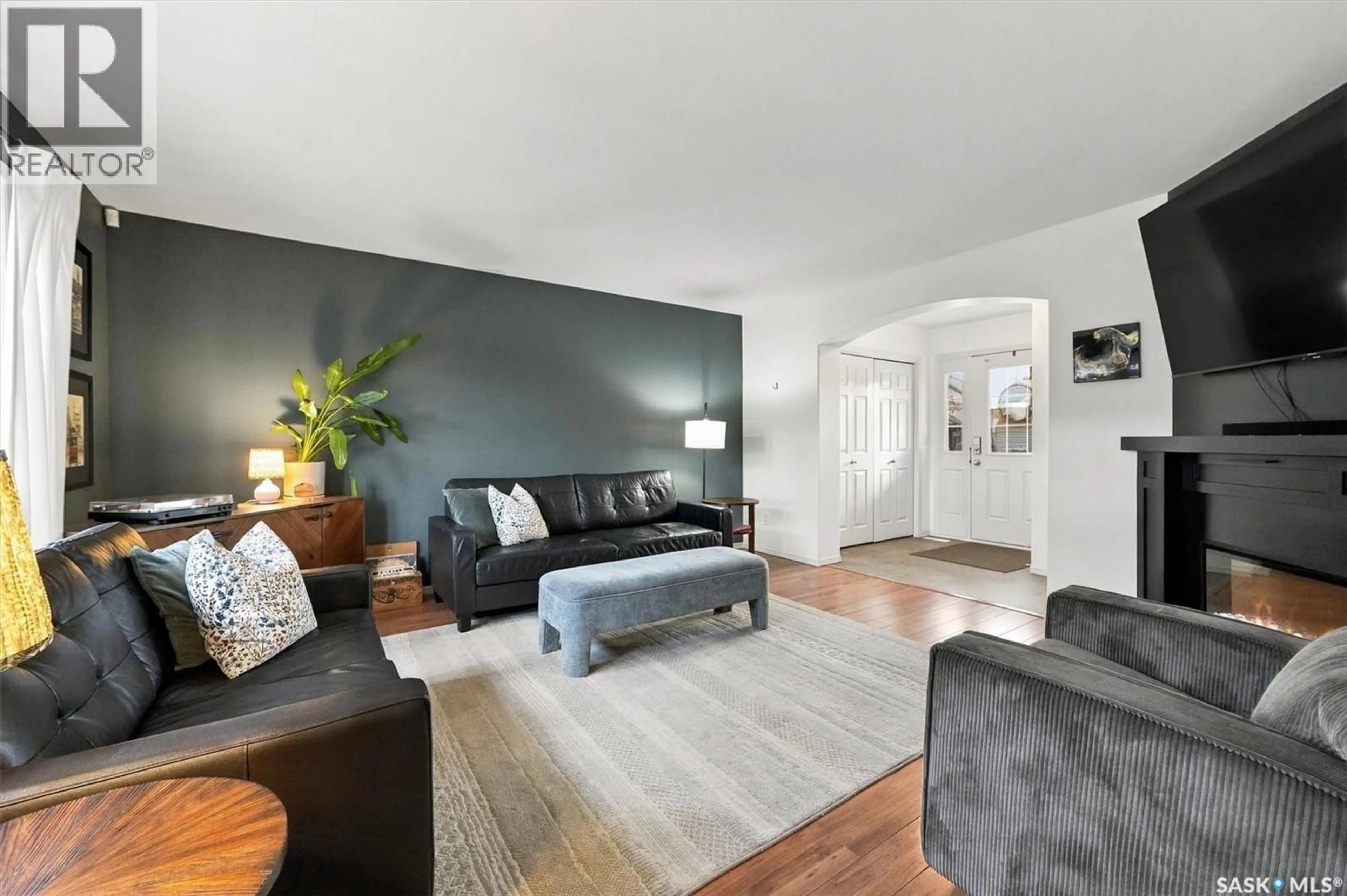 Living room with furniture, wood/laminate floor for 311 DENHAM COURT, Saskatoon Saskatchewan S7R1E5