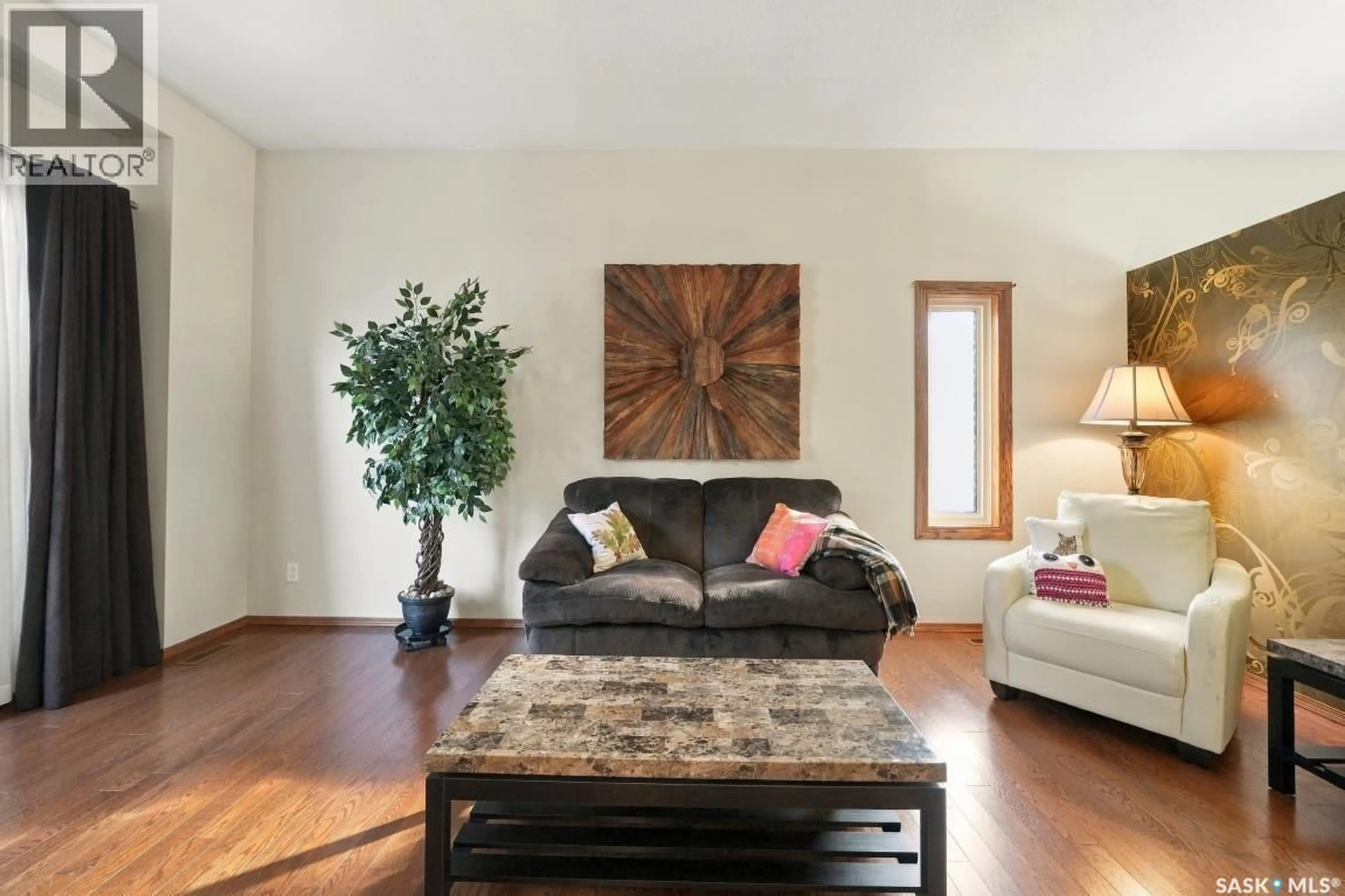 Living room with furniture, wood/laminate floor for 410 BRONSON CRESCENT, Saskatoon Saskatchewan S7J5E2
