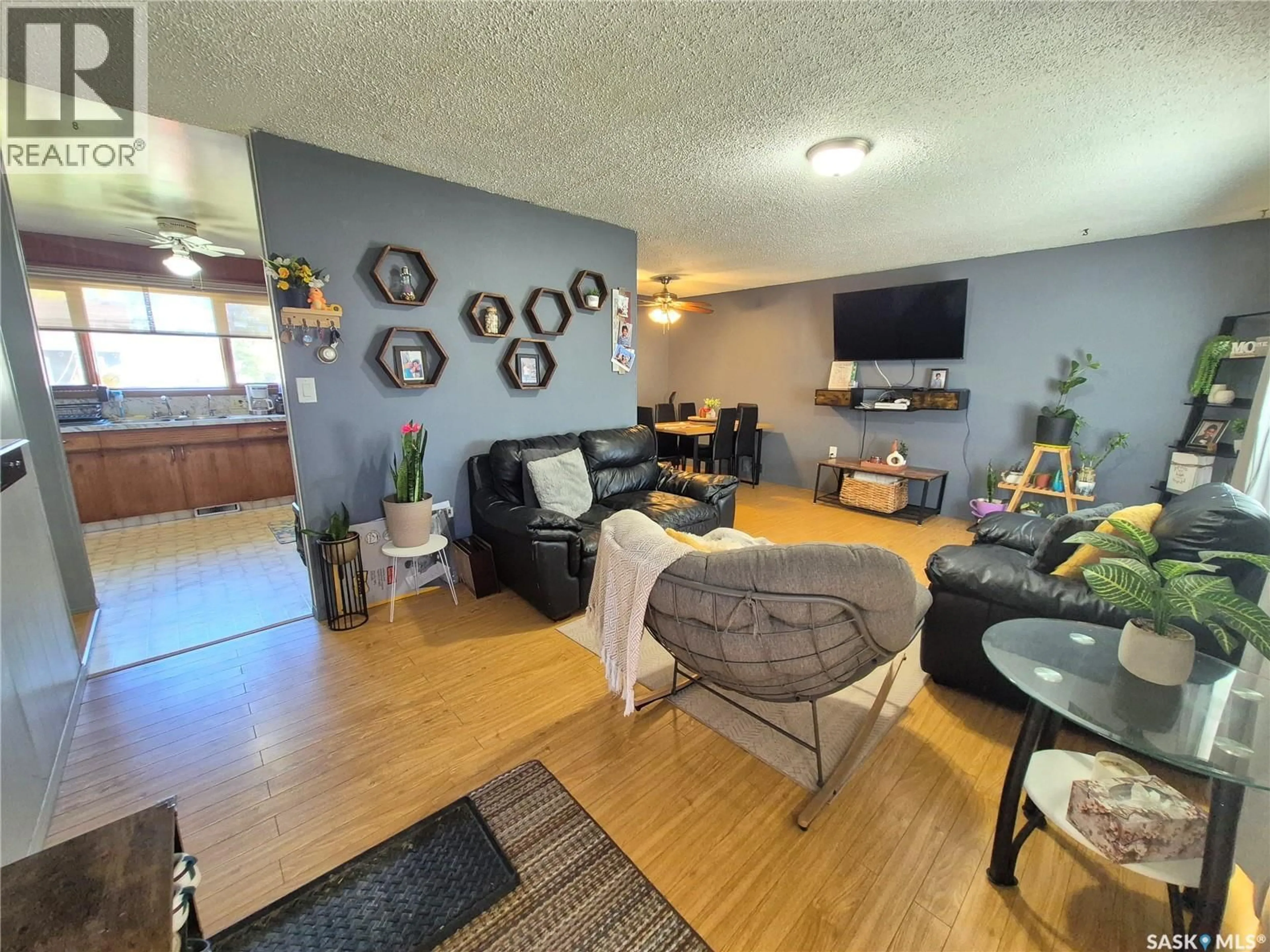 Living room with furniture, wood/laminate floor for 505 BERTRAND AVENUE, Radville Saskatchewan S0C2G0