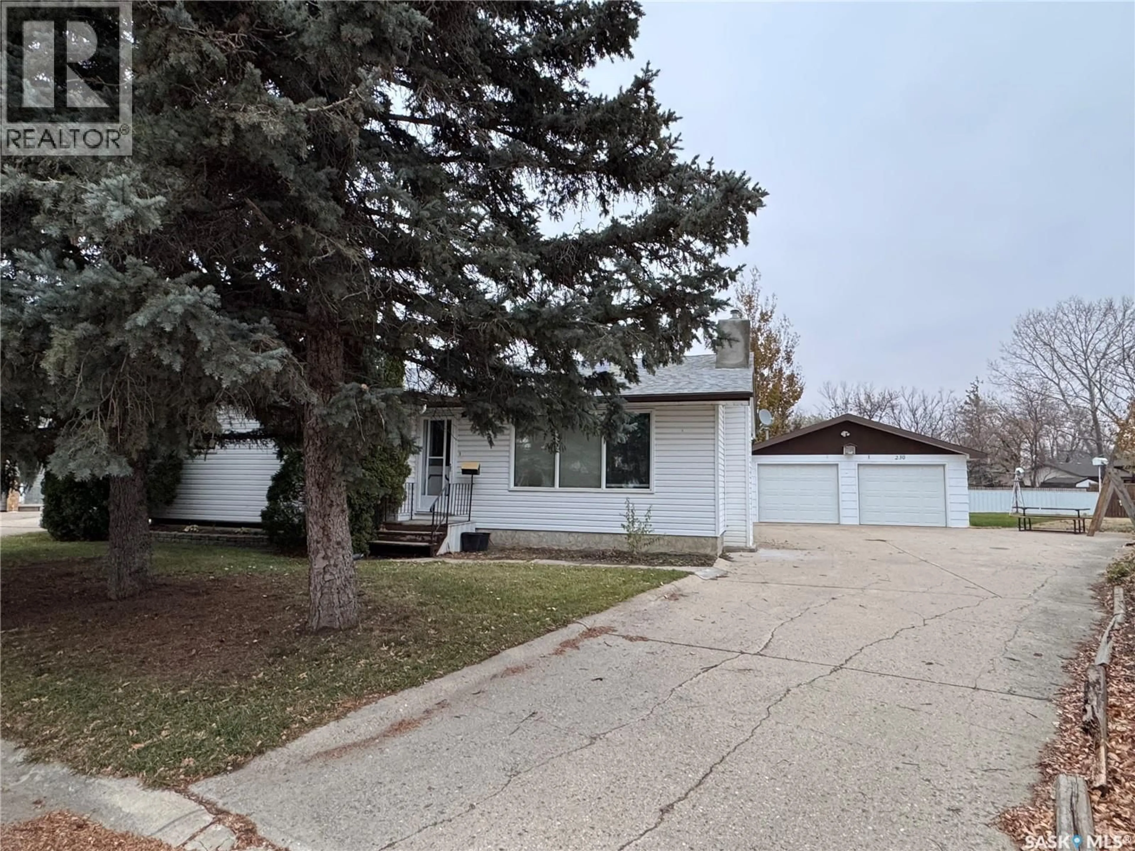 Home with vinyl exterior material, street for 230 HARVEY BAY, Weyburn Saskatchewan S4H2S7