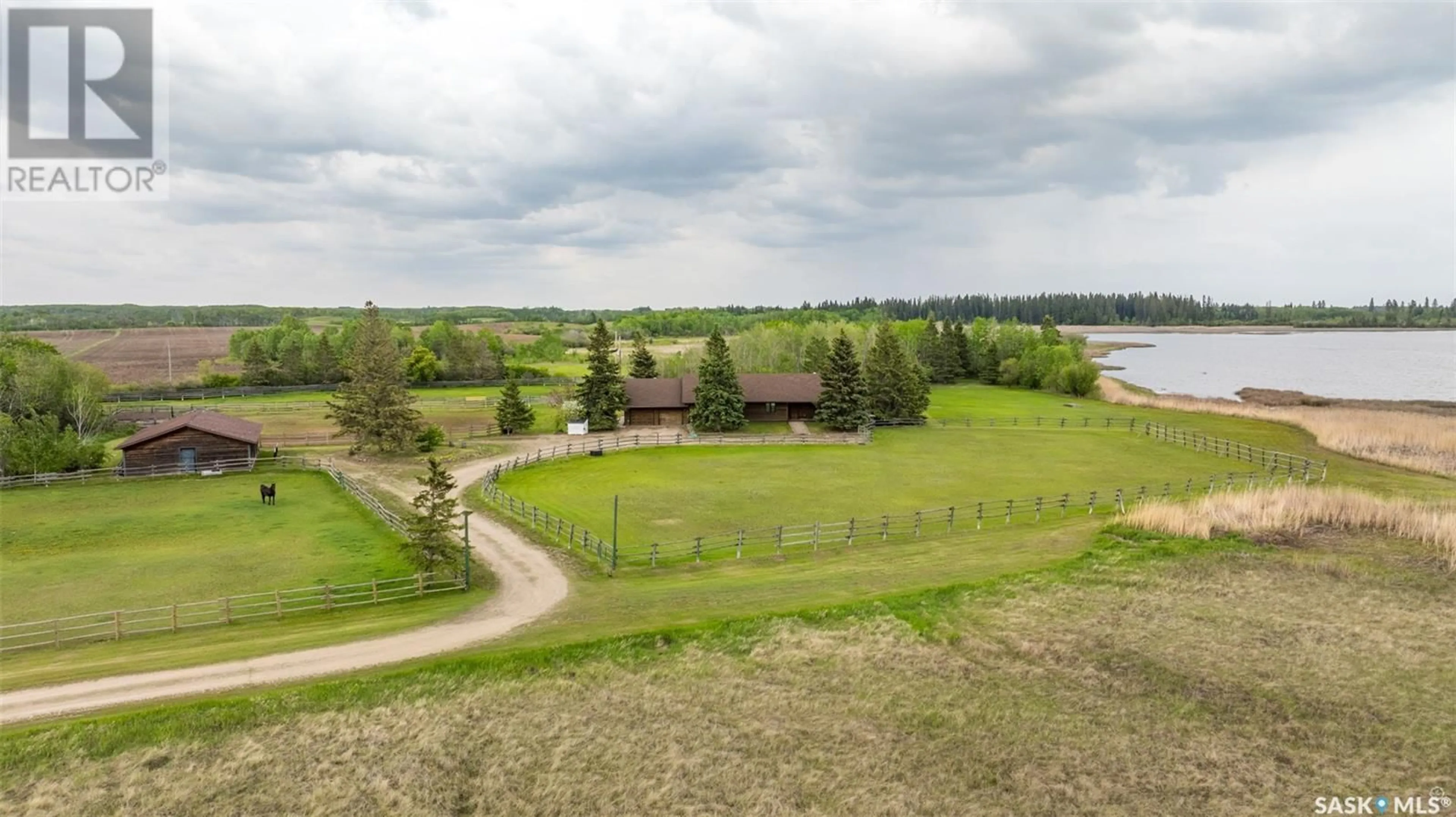 A pic from exterior of the house or condo, the fenced backyard for Hurd Lake Acreage, Leask Rm No. 464 Saskatchewan S0J1M0