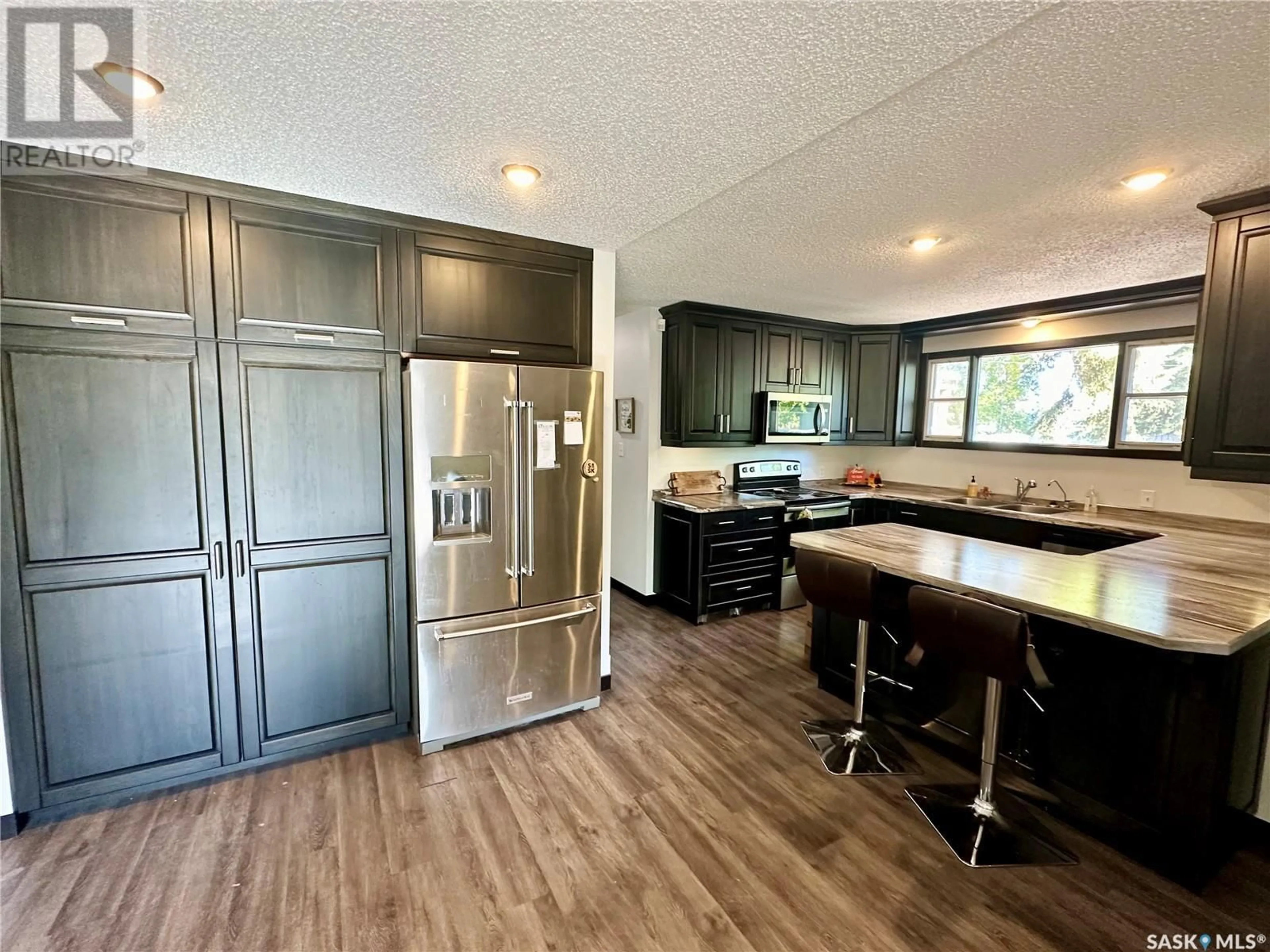 Open concept kitchen, wood/laminate floor for 1512 106TH STREET, North Battleford Saskatchewan S9A1X8