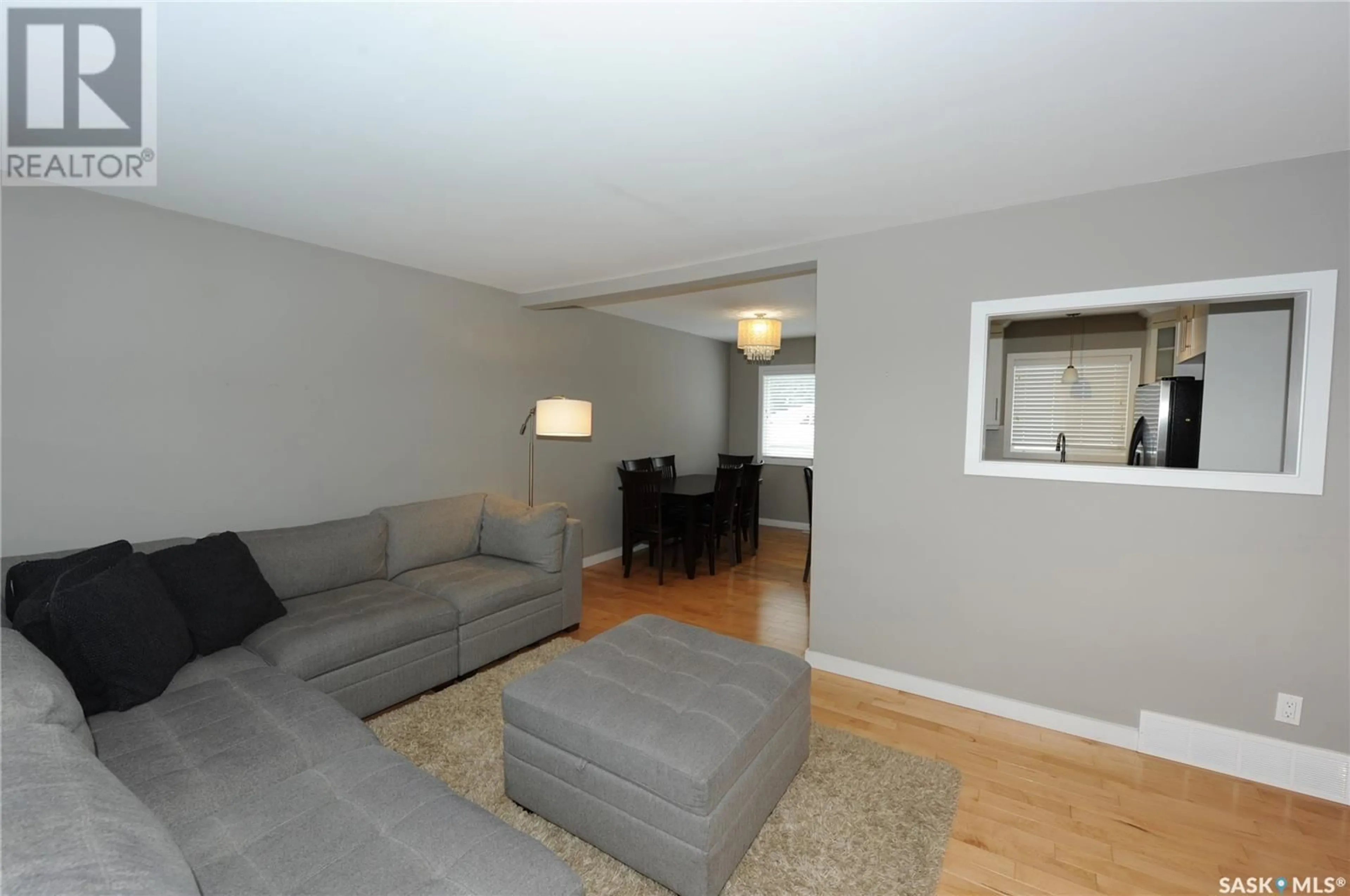 Living room with furniture, wood/laminate floor for 1107 McMillan AVENUE, Saskatoon Saskatchewan S7L2T9