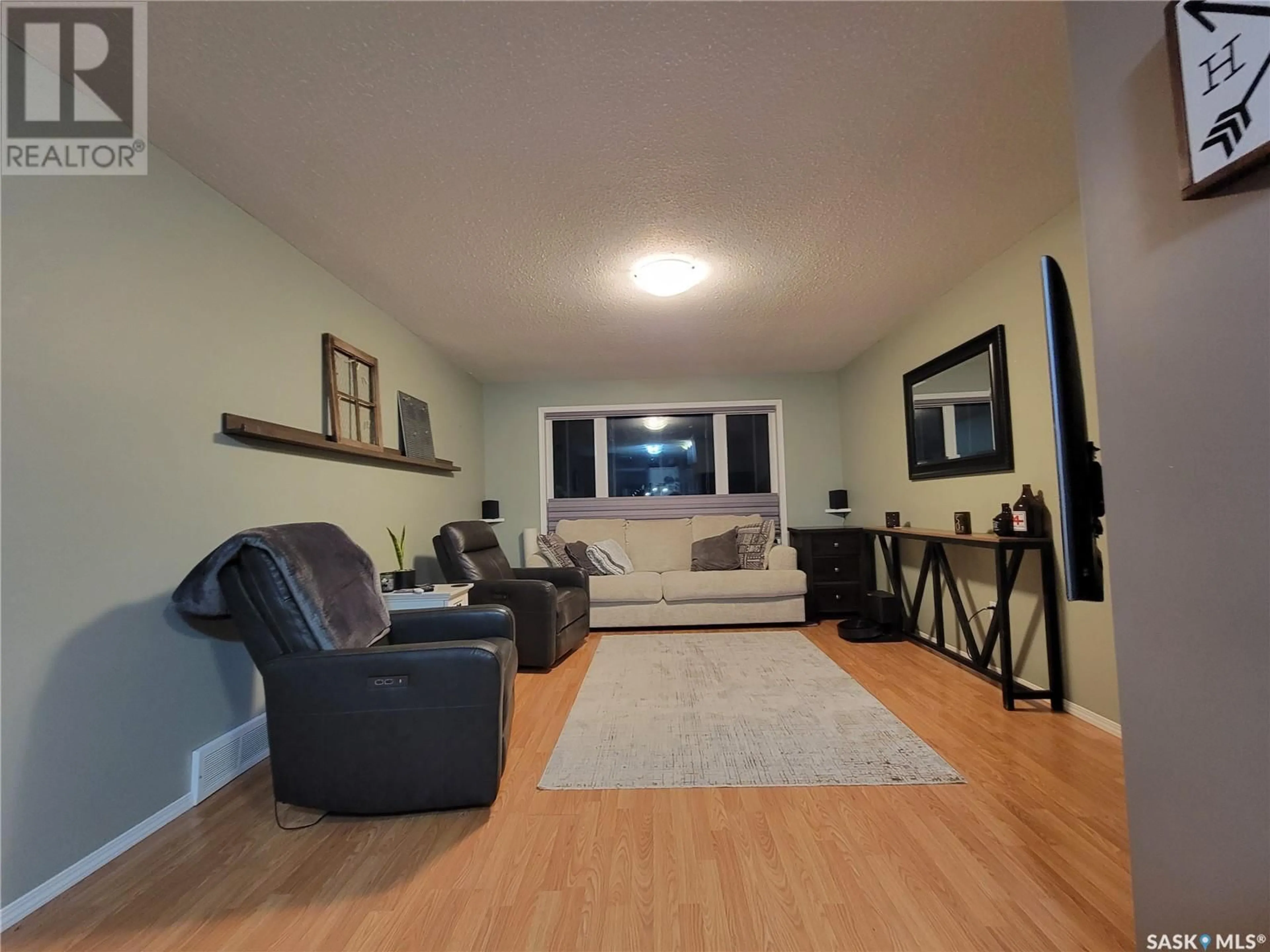 Living room with furniture, wood/laminate floor for 5305 Herald STREET N, Macklin Saskatchewan S0L2C0