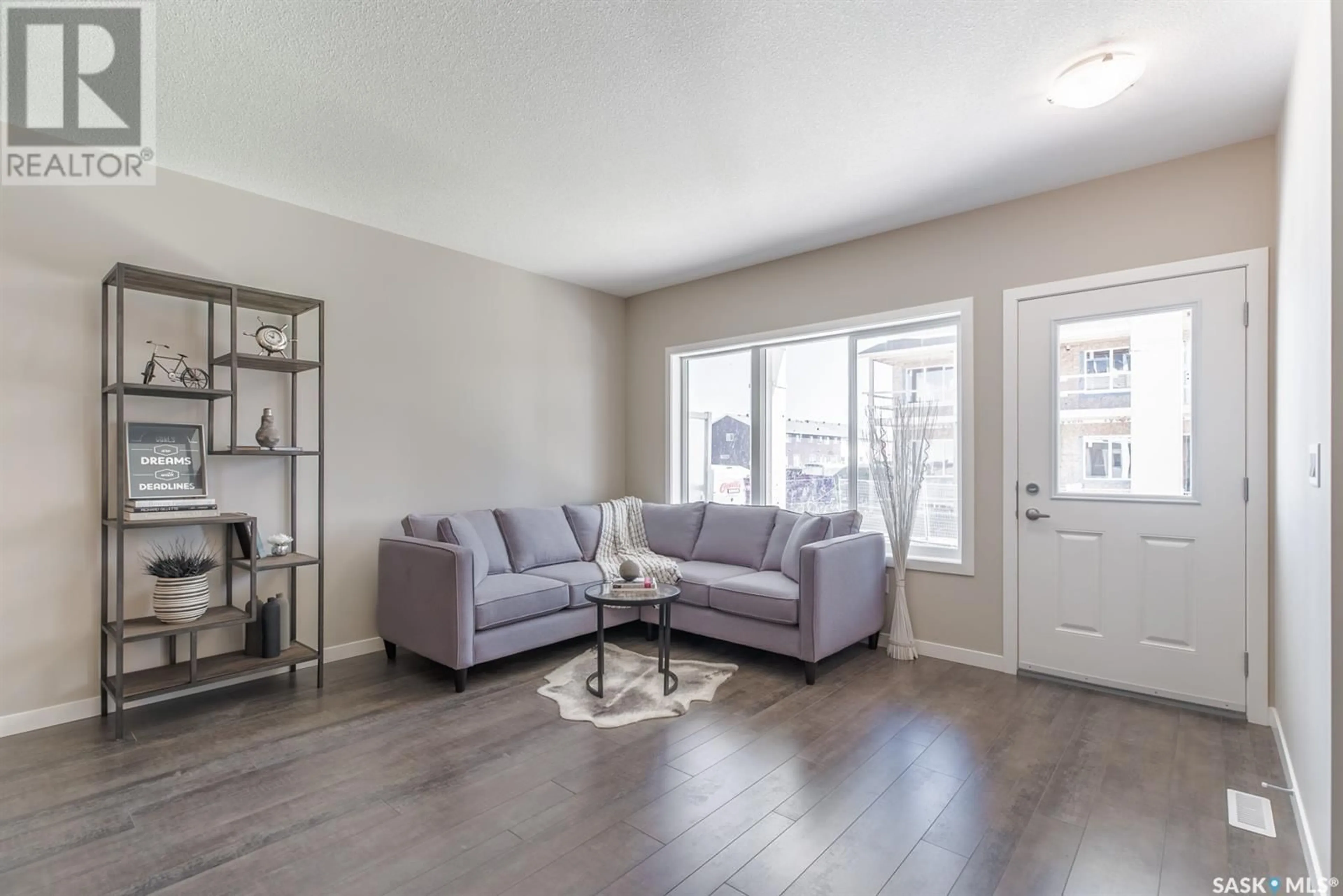 Living room with furniture, wood/laminate floor for 508A 3359 Green Poppy STREET, Regina Saskatchewan S4V3P6