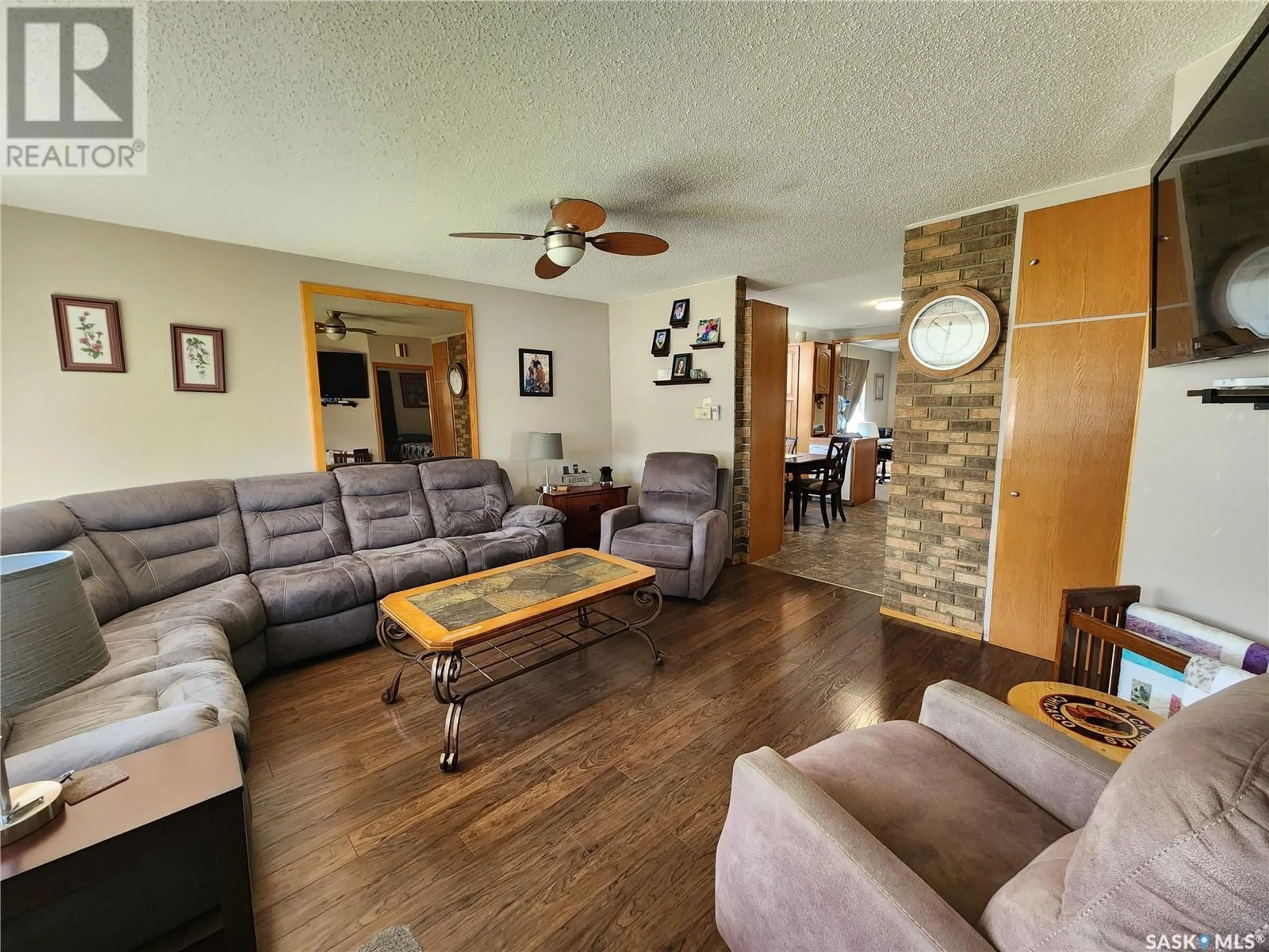 Living room with furniture, wood/laminate floor for 219 9th STREET NE, Weyburn Saskatchewan S4H1E9