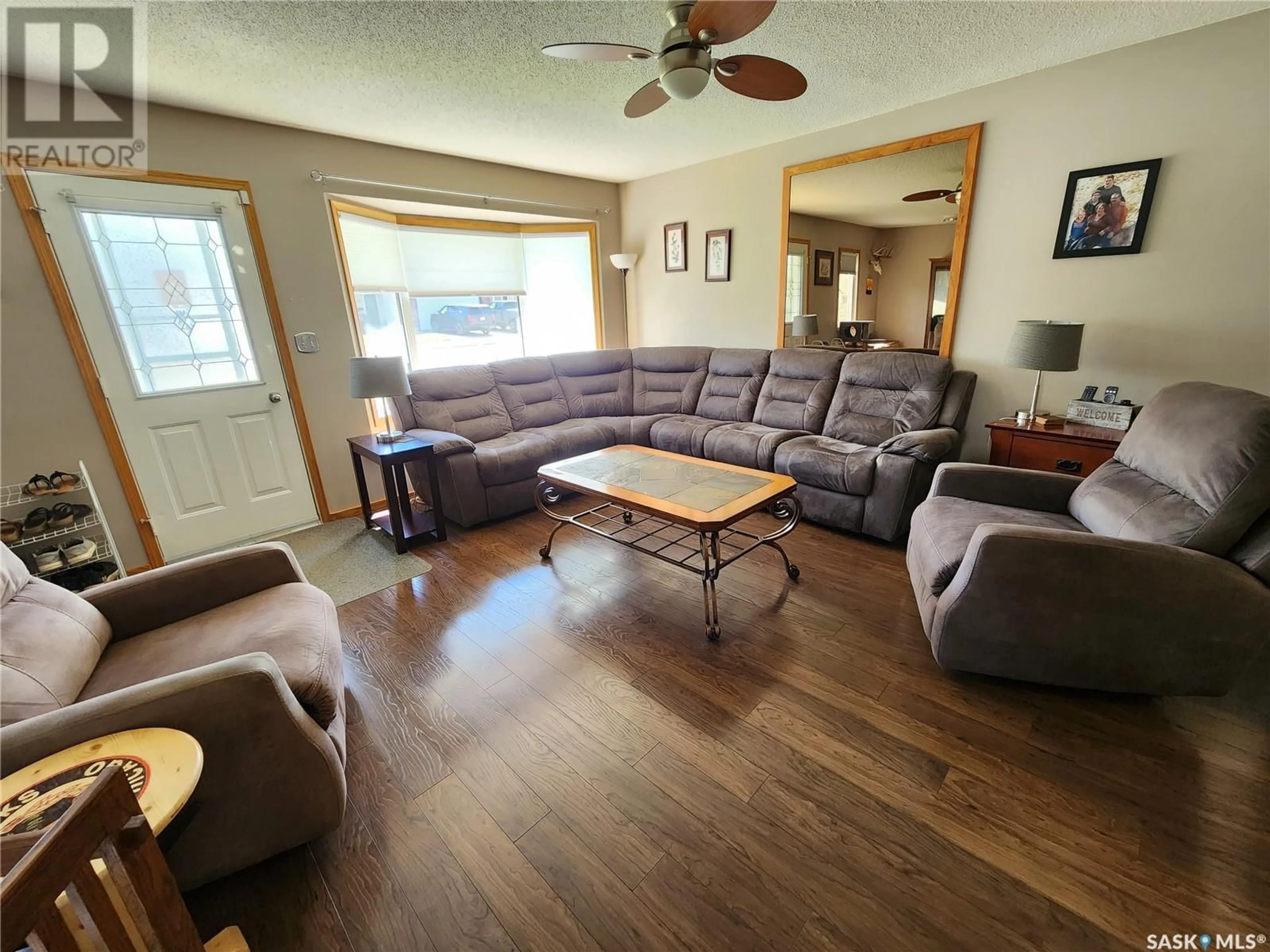 Living room with furniture, wood/laminate floor for 219 9th STREET NE, Weyburn Saskatchewan S4H1E9