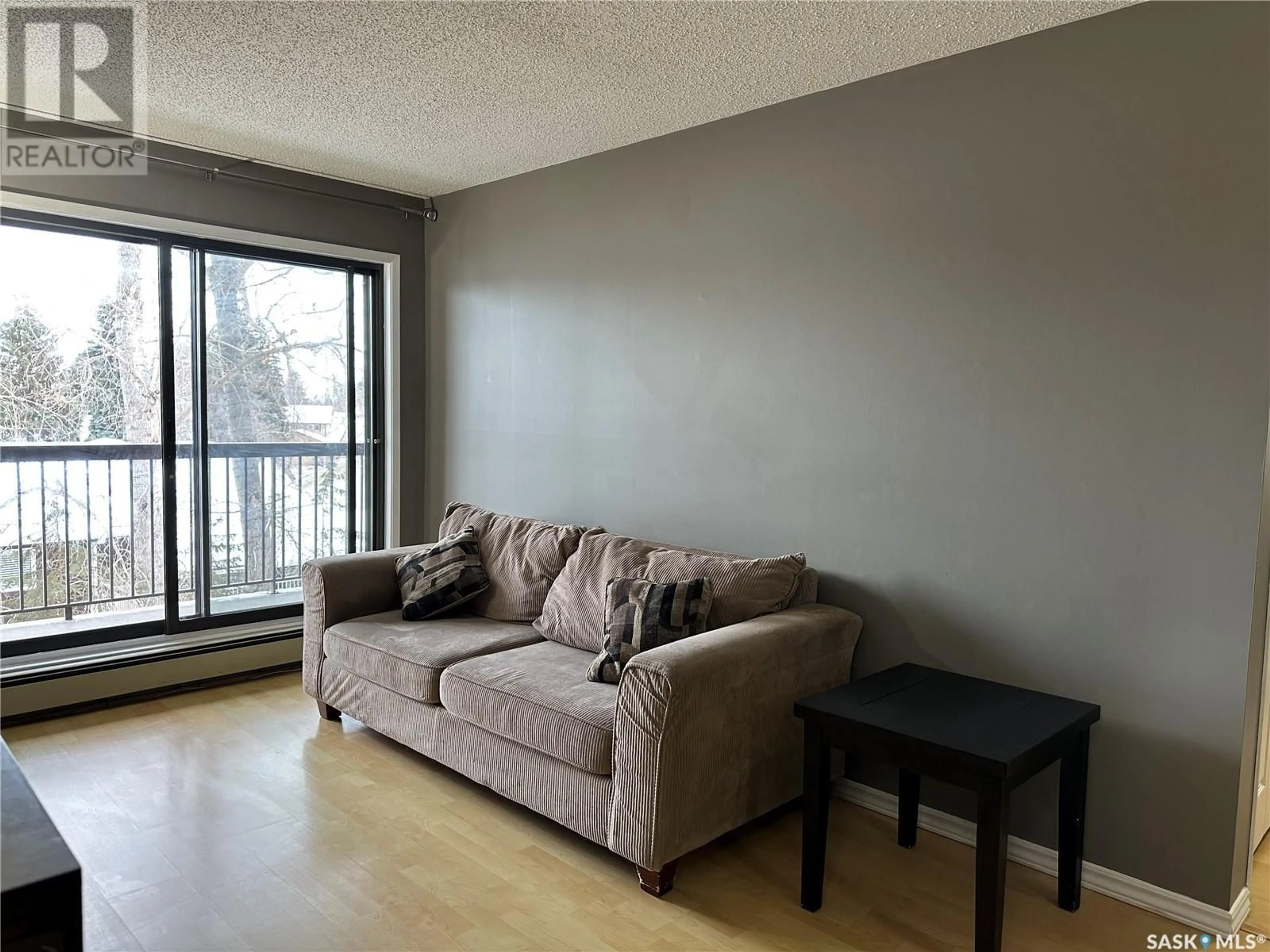 Living room with furniture, wood/laminate floor for 204 225 Kingsmere BOULEVARD, Saskatoon Saskatchewan S7J4J6