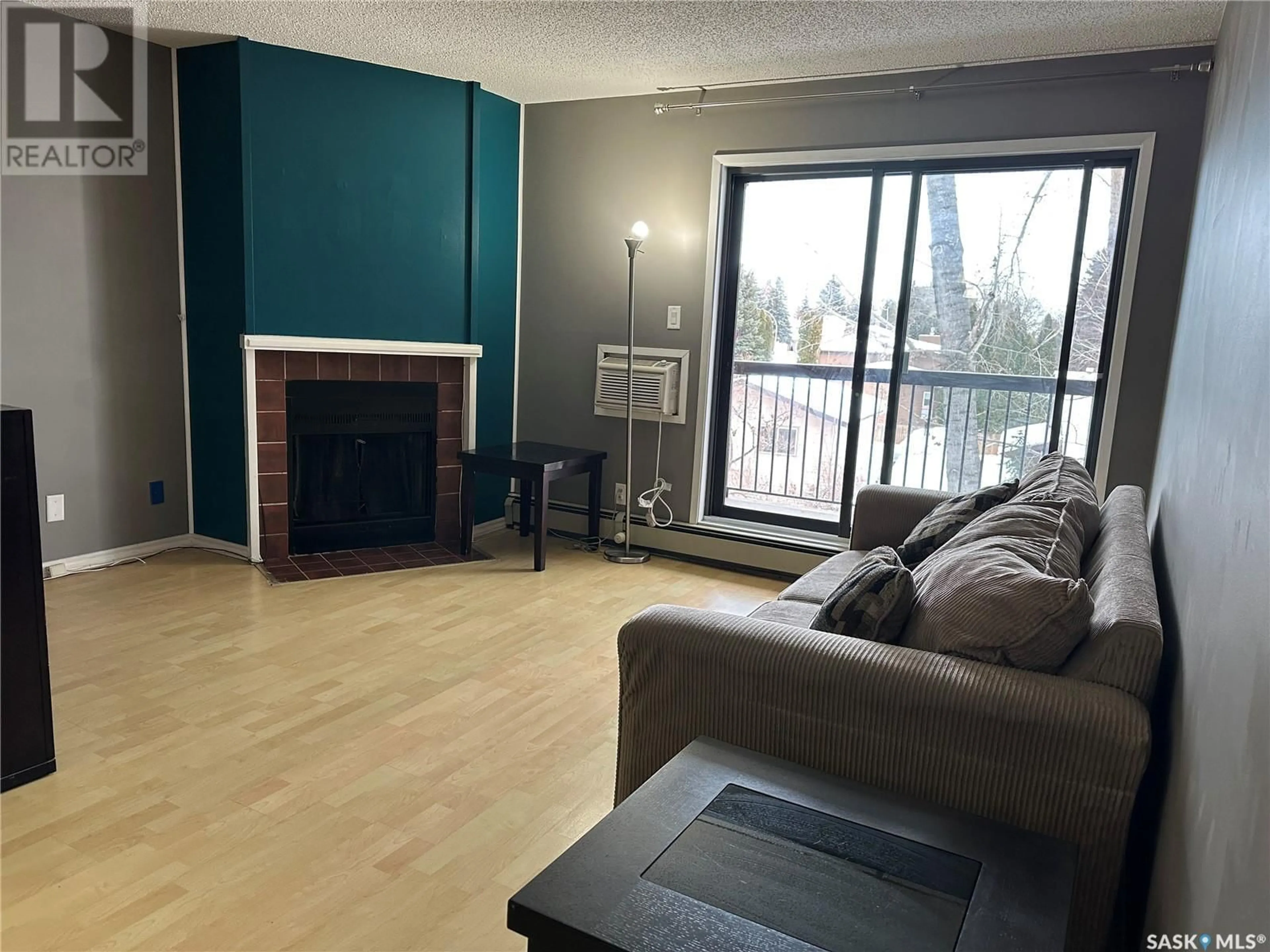 Living room with furniture, wood/laminate floor for 204 225 Kingsmere BOULEVARD, Saskatoon Saskatchewan S7J4J6