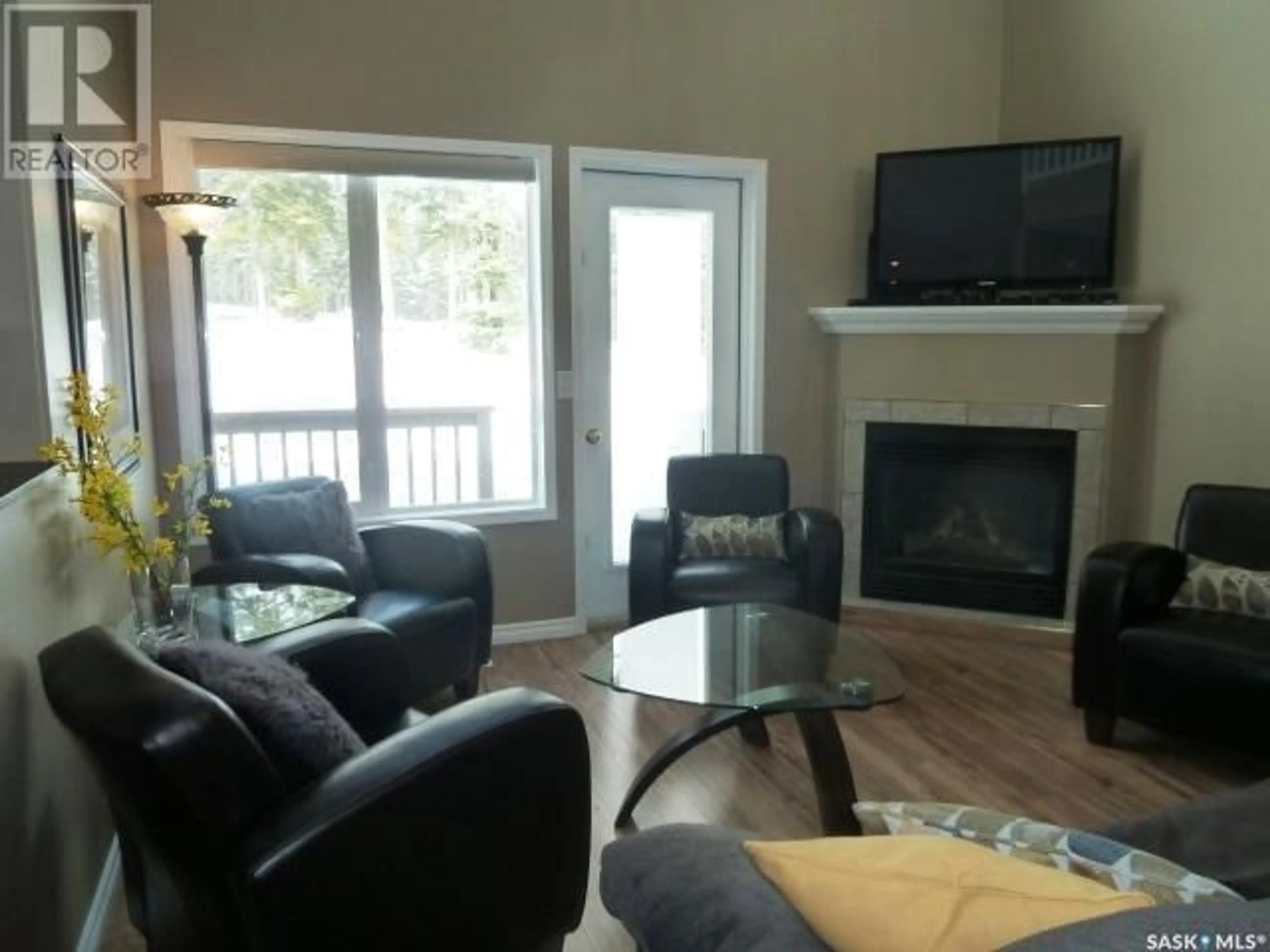 Living room with furniture, wood/laminate floor for 10 Fairview WAY, Elk Ridge Saskatchewan S0J0N0