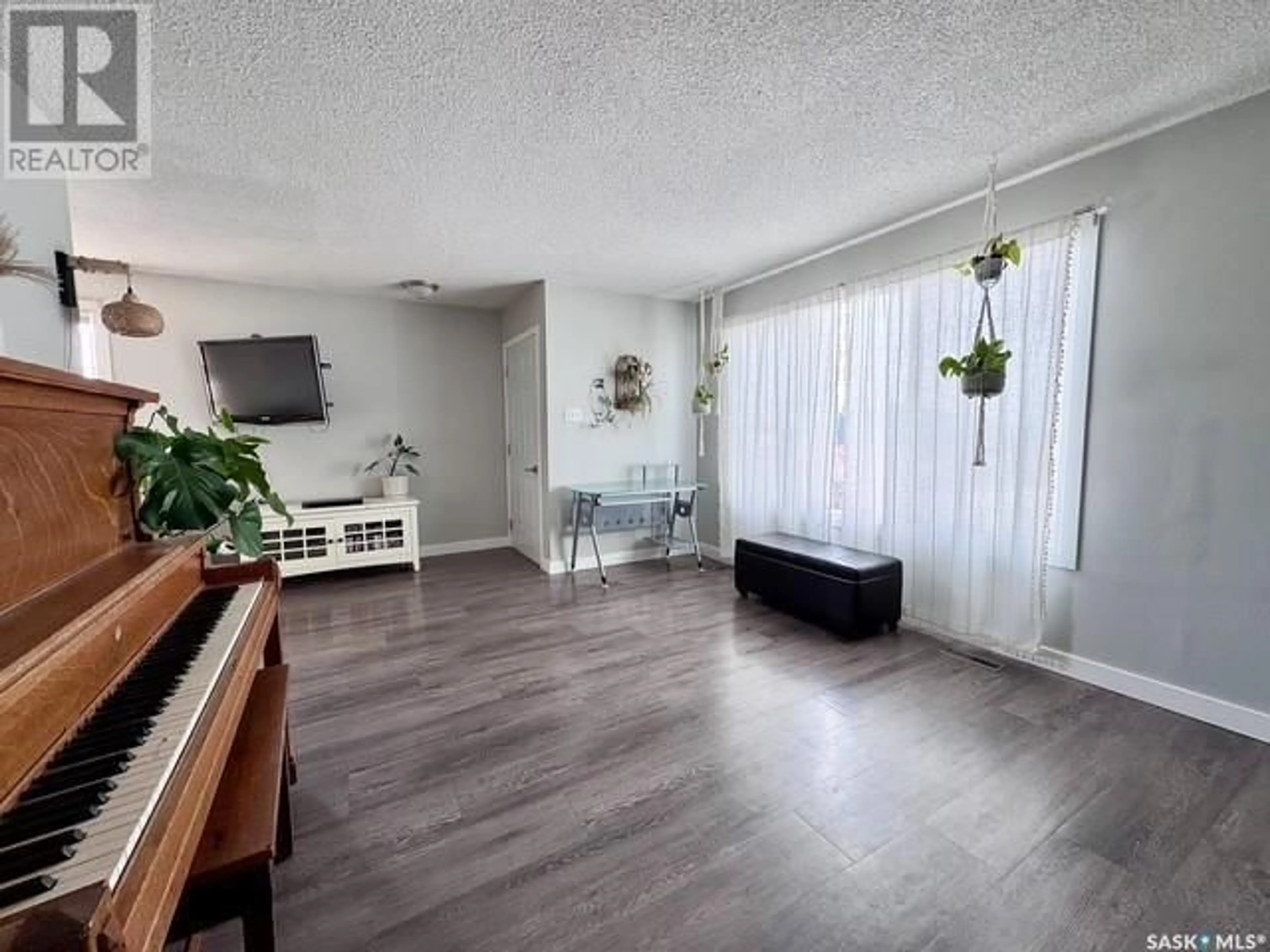 Living room with furniture, wood/laminate floor for 211 & 215 18th AVENUE NE, Swift Current Saskatchewan S9H2Y2