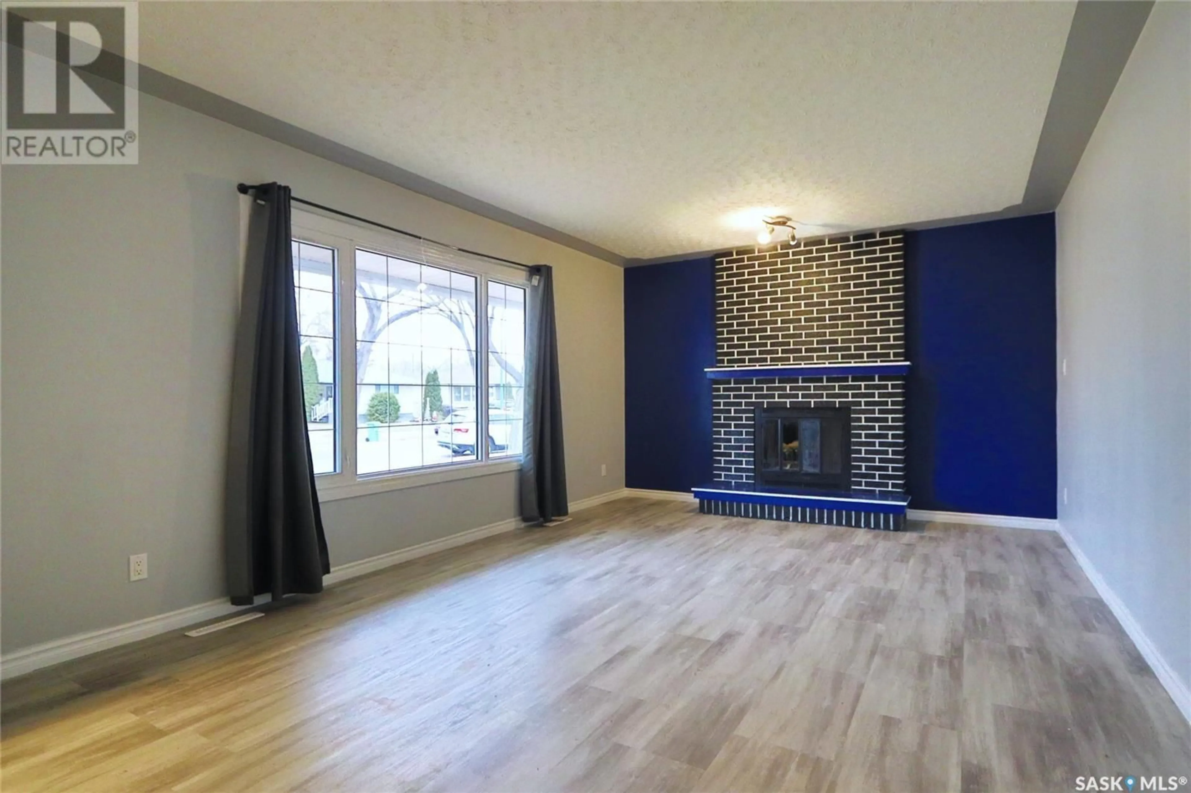 Living room with furniture, wood/laminate floor for 4529 England ROAD, Regina Saskatchewan S4R4P6