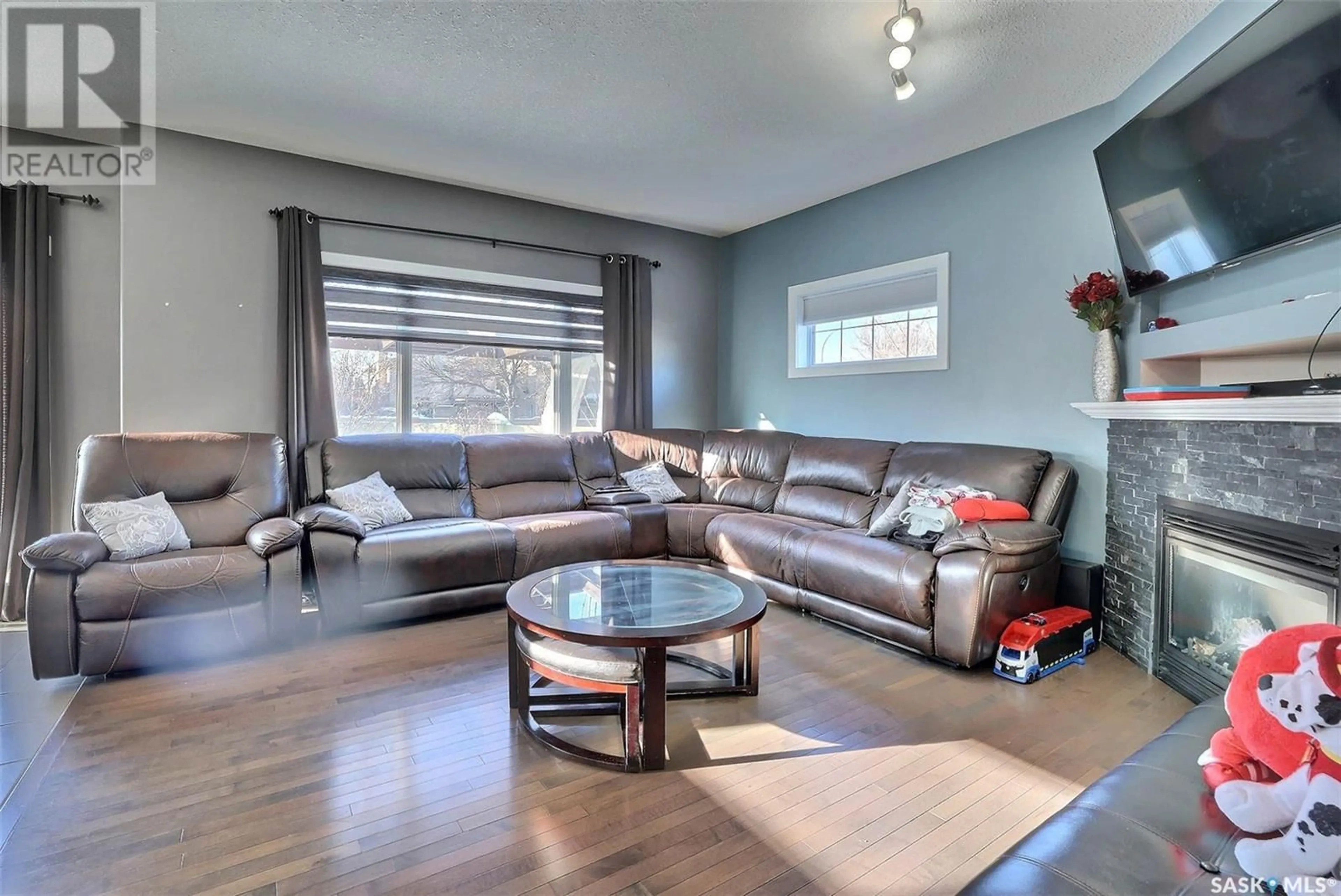 Living room with furniture, wood/laminate floor for 3601 Green Moss LANE, Regina Saskatchewan S4V1M2