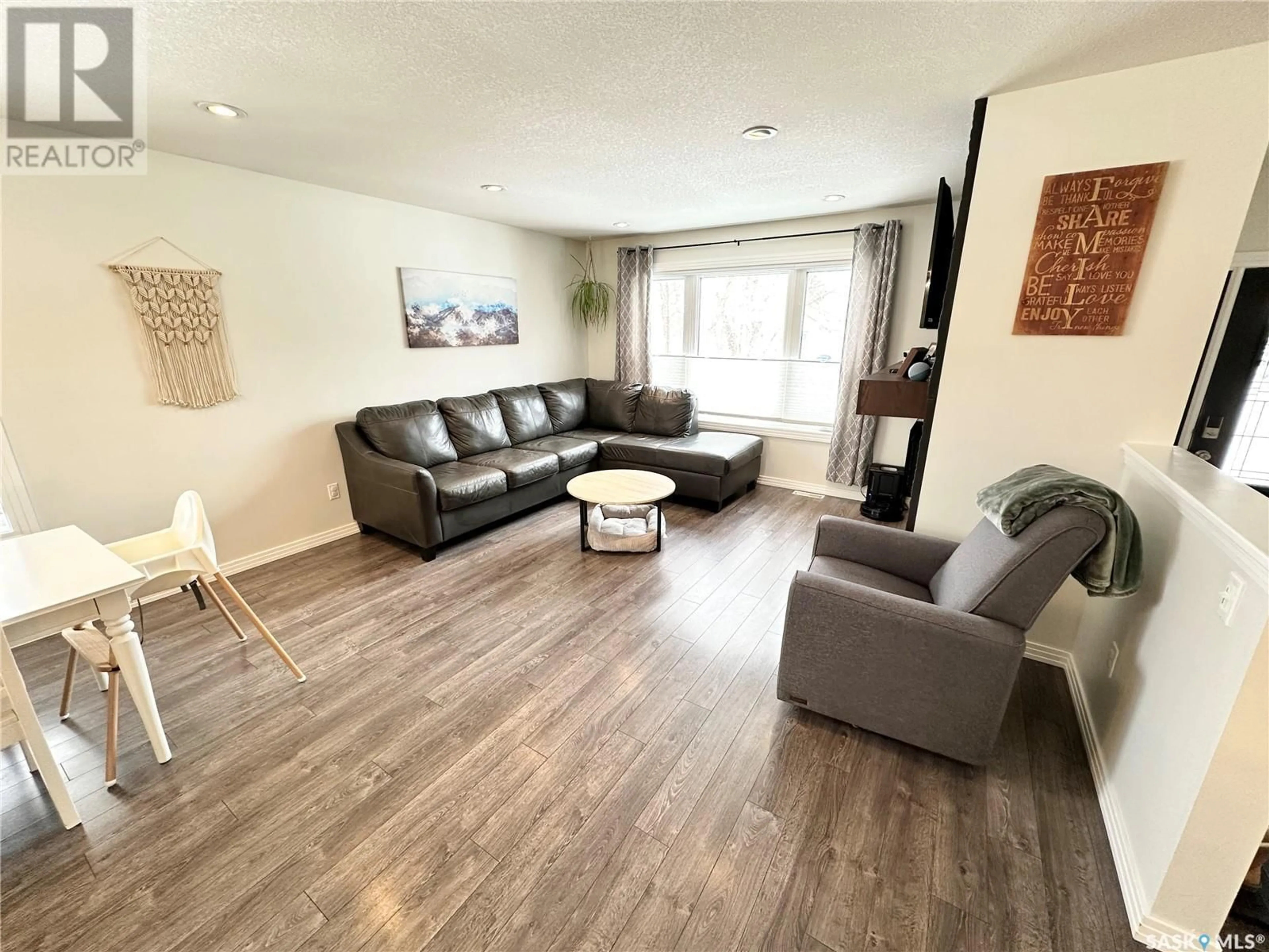 Living room with furniture, wood/laminate floor for 43 9th STREET, Weyburn Saskatchewan S4H1E6