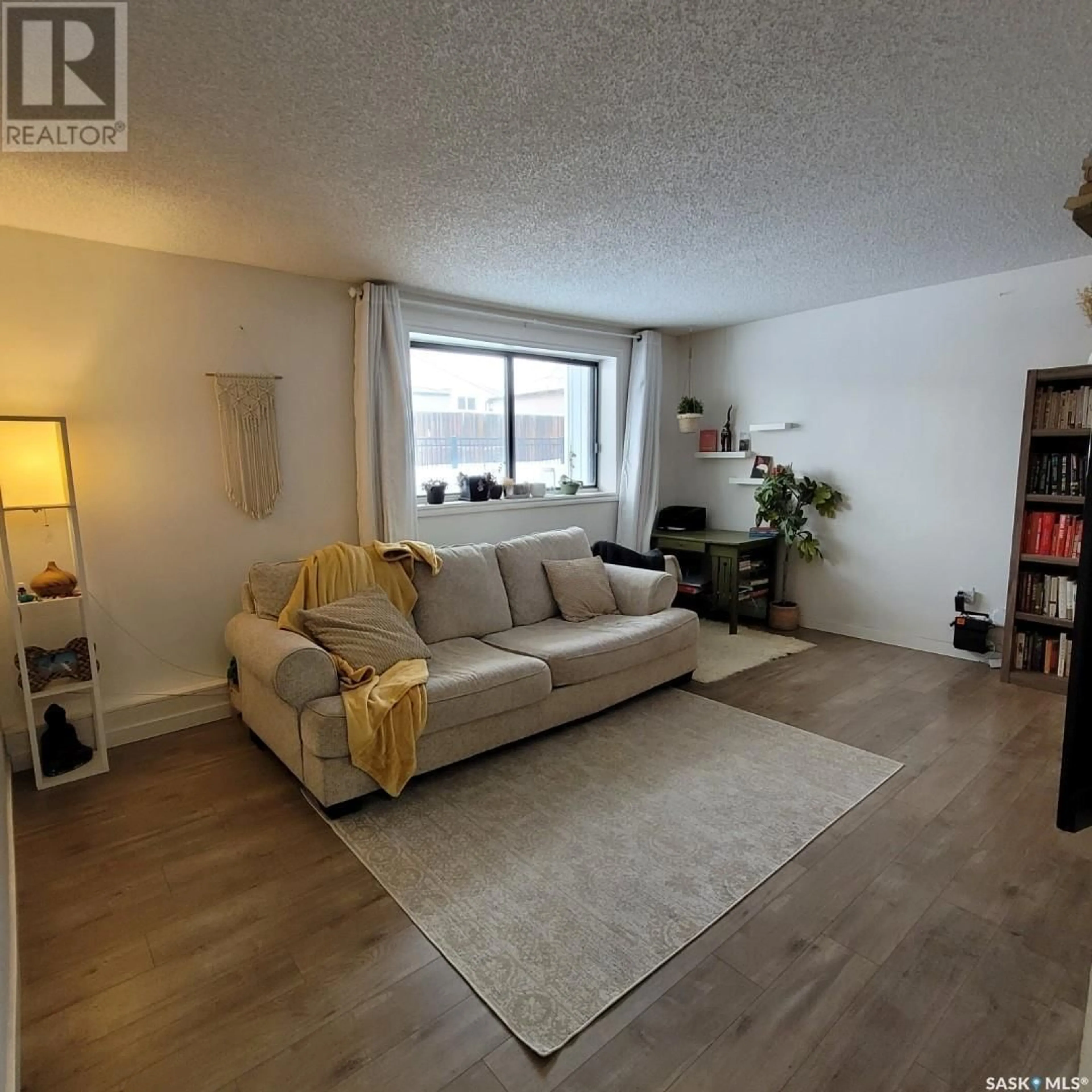 Living room with furniture, wood/laminate floor for 108 258 Pinehouse PLACE, Saskatoon Saskatchewan S7K4X1