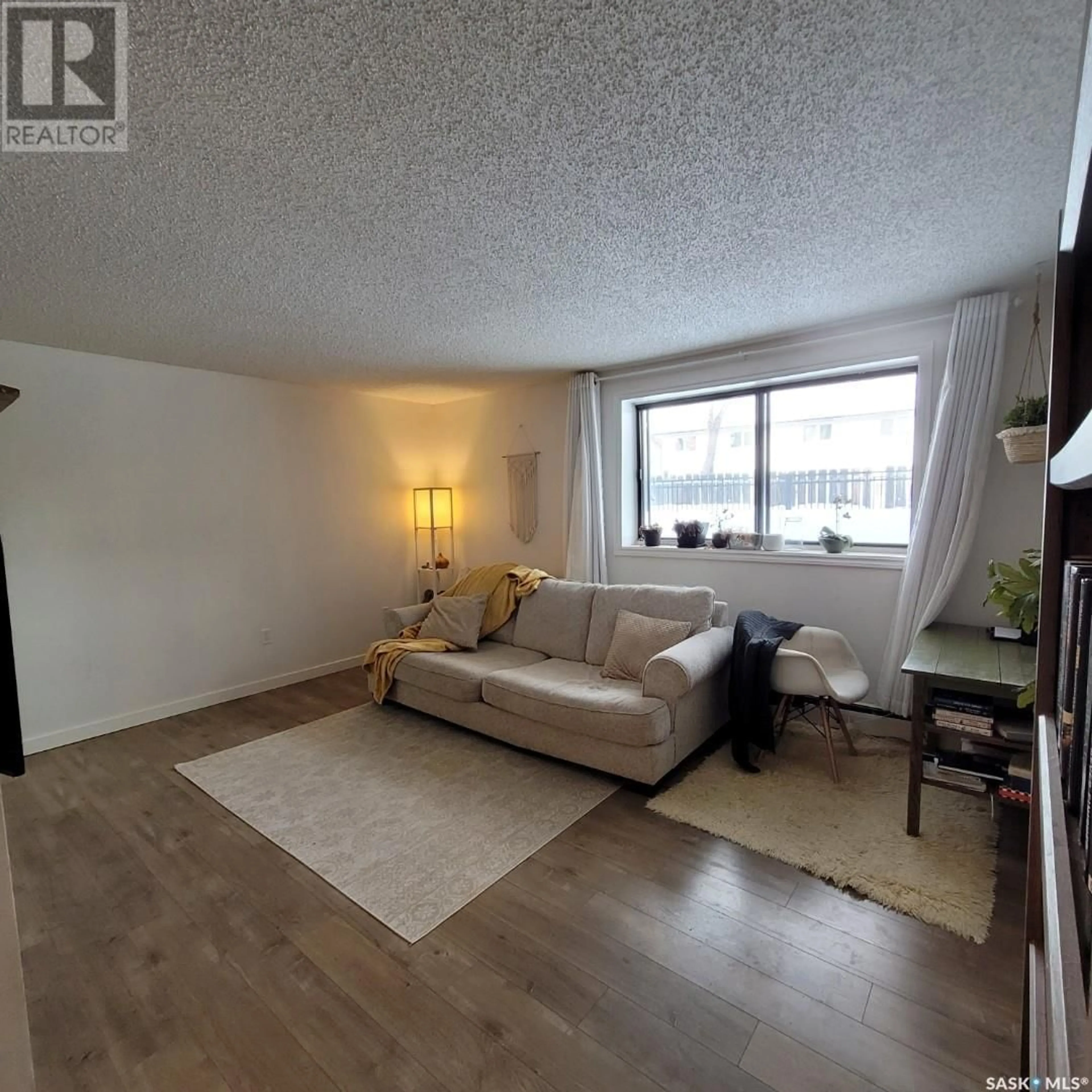 Living room with furniture, wood/laminate floor for 108 258 Pinehouse PLACE, Saskatoon Saskatchewan S7K4X1