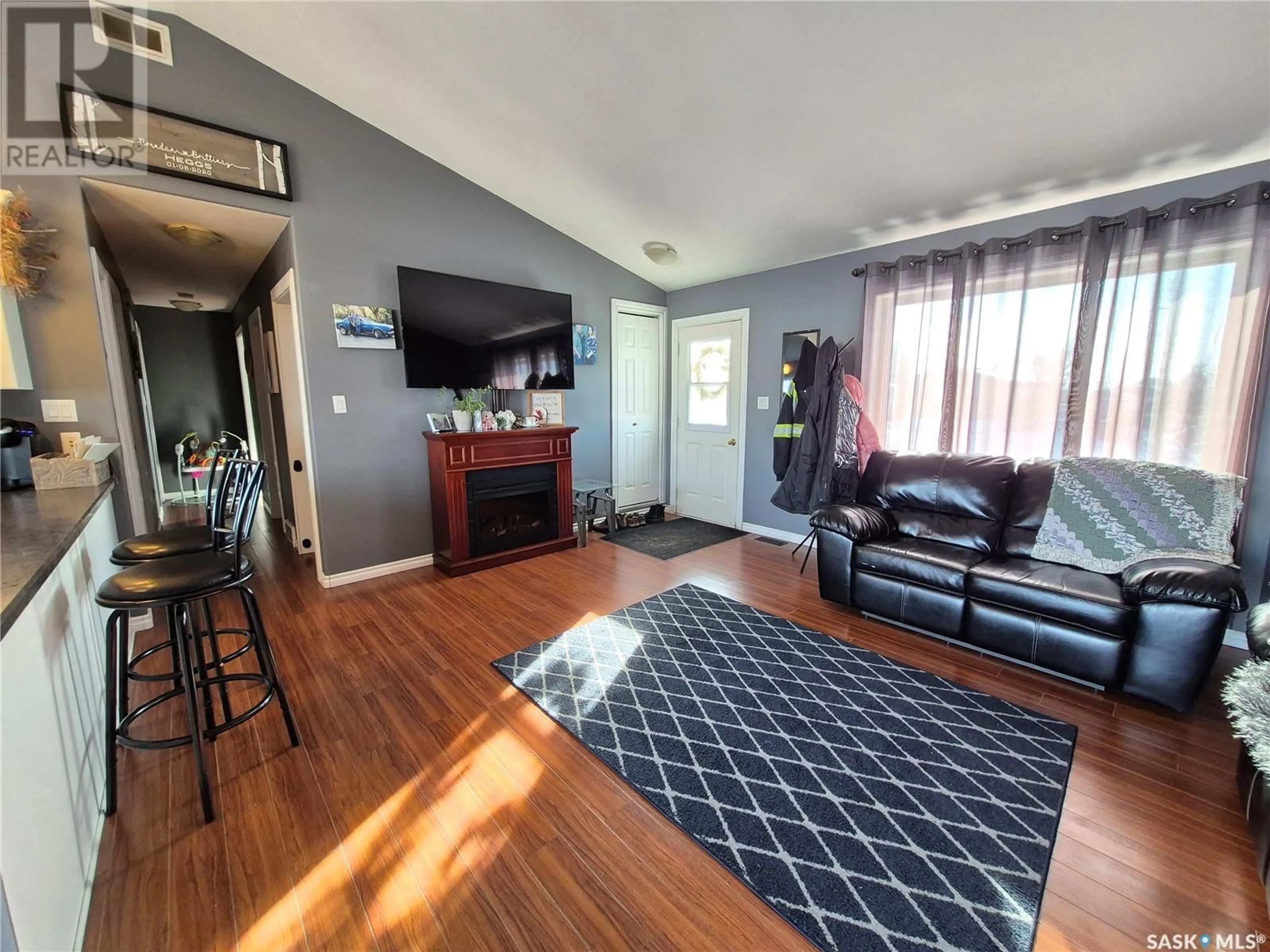 Living room with furniture, wood/laminate floor for 345 9th AVENUE SE, Weyburn Saskatchewan S4H3L7