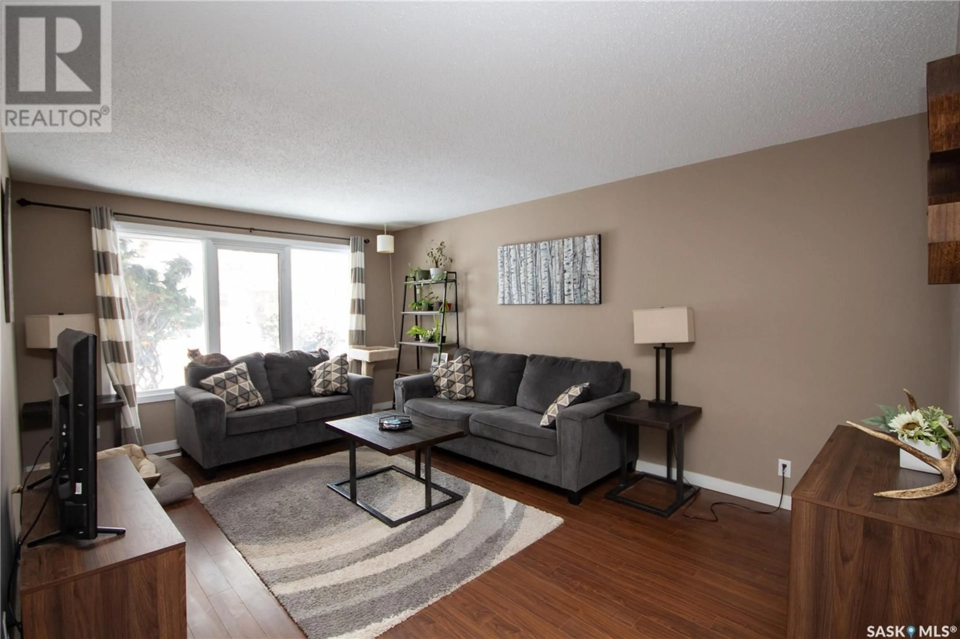 Living room with furniture, wood/laminate floor for 1751 93rd STREET, North Battleford Saskatchewan S9A0C7